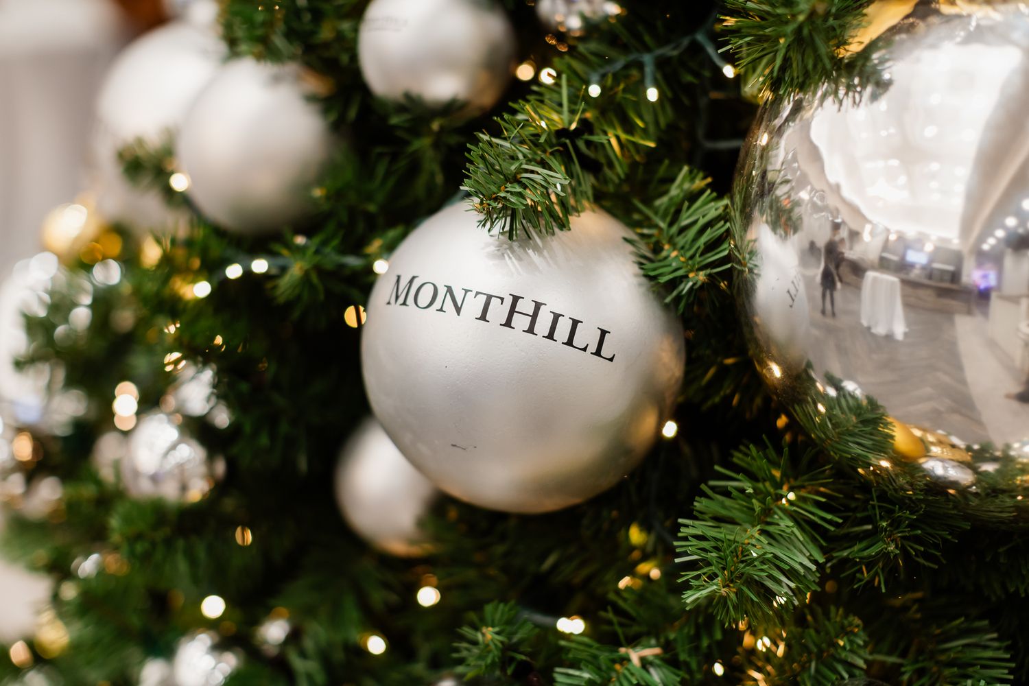 White and gold ornaments decorate a festive Christmas tree with twinkling lights.