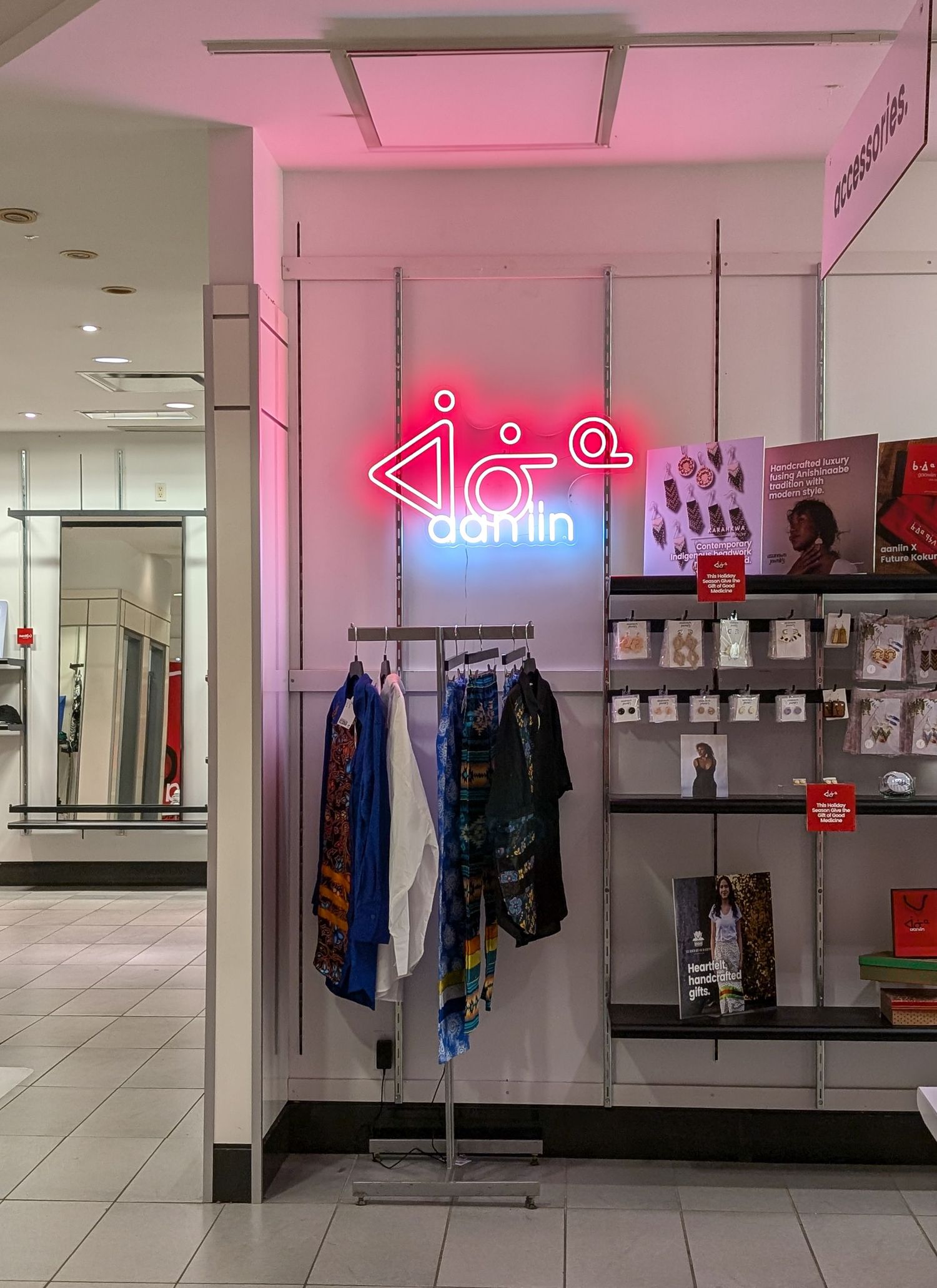 Damlin store display with pink neon sign, clothing rack, and merchandise shelves inside a modern retail space.