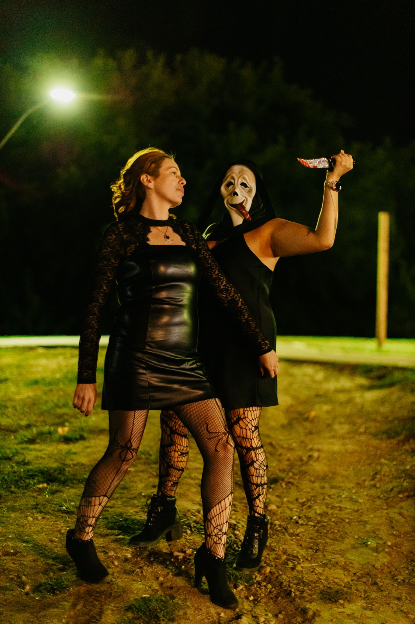 Artistic nighttime photoshoot featuring dark clothing and dramatic poses.