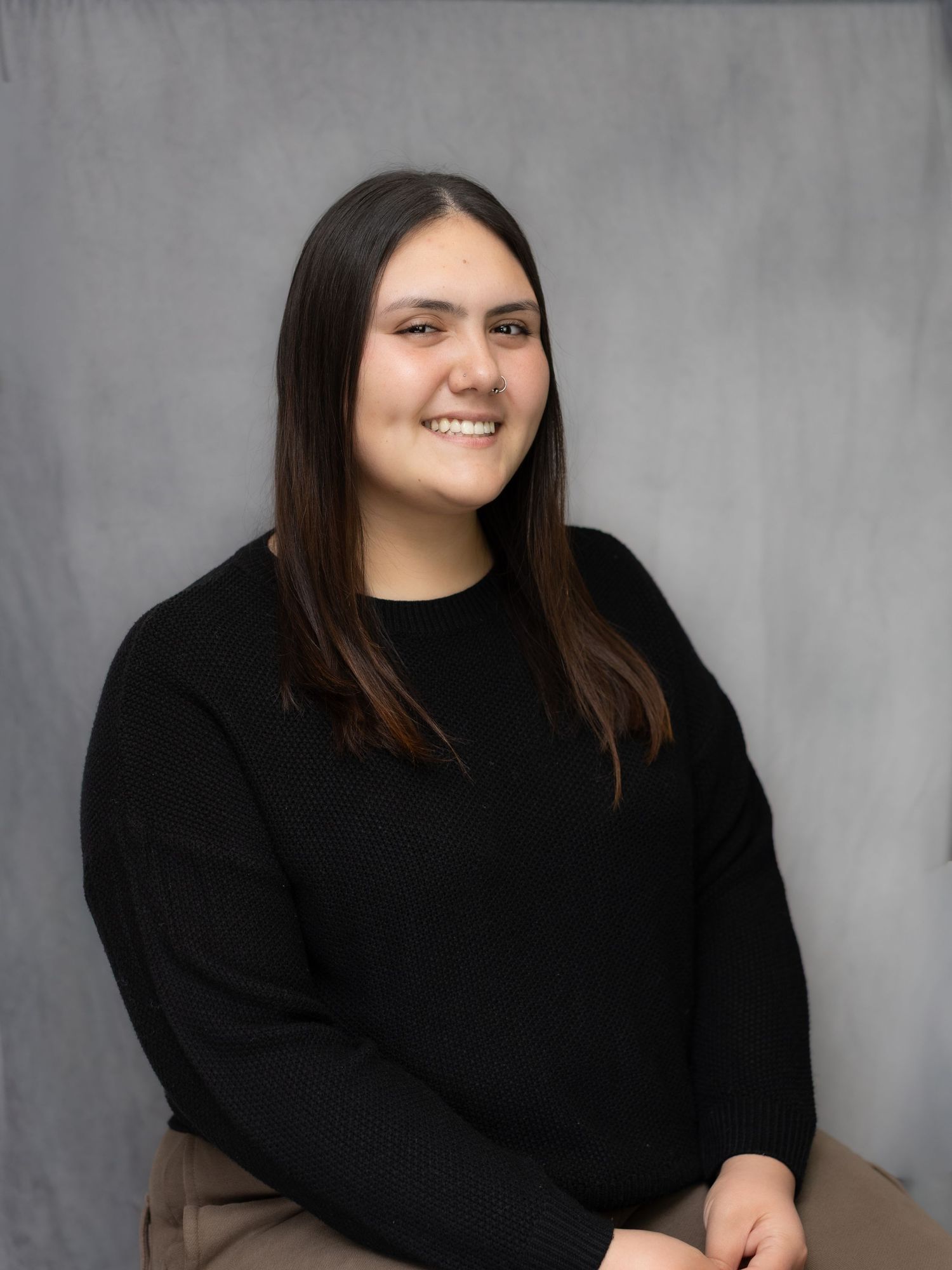 A series of studio portraits showing a person in a black sweater against a gray background.