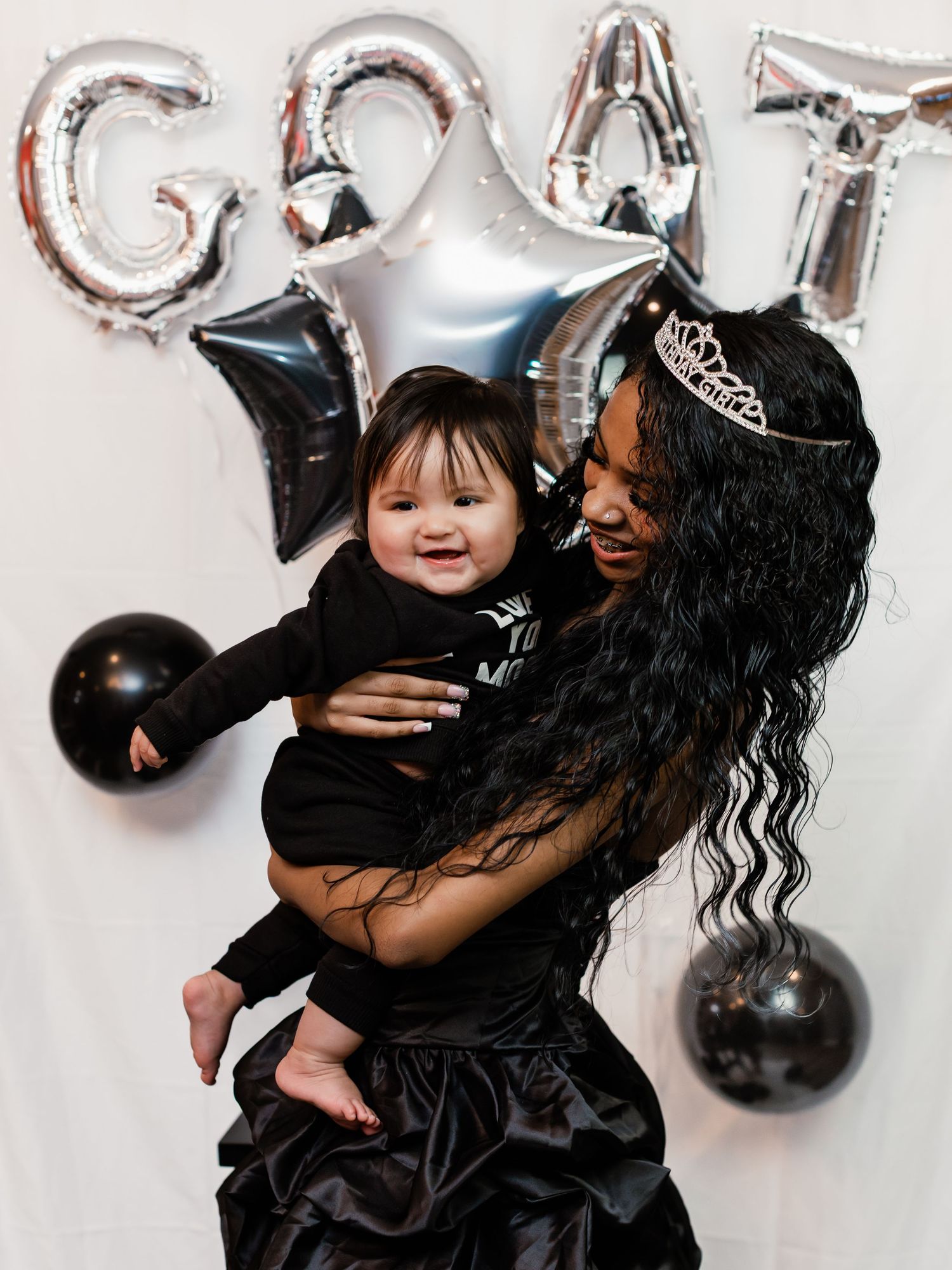 Sweet moment captured with silver balloon decorations and black formal attire.