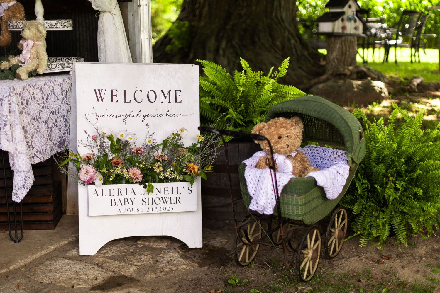 Garden-themed wedding welcome display with vintage decor elements and greenery.