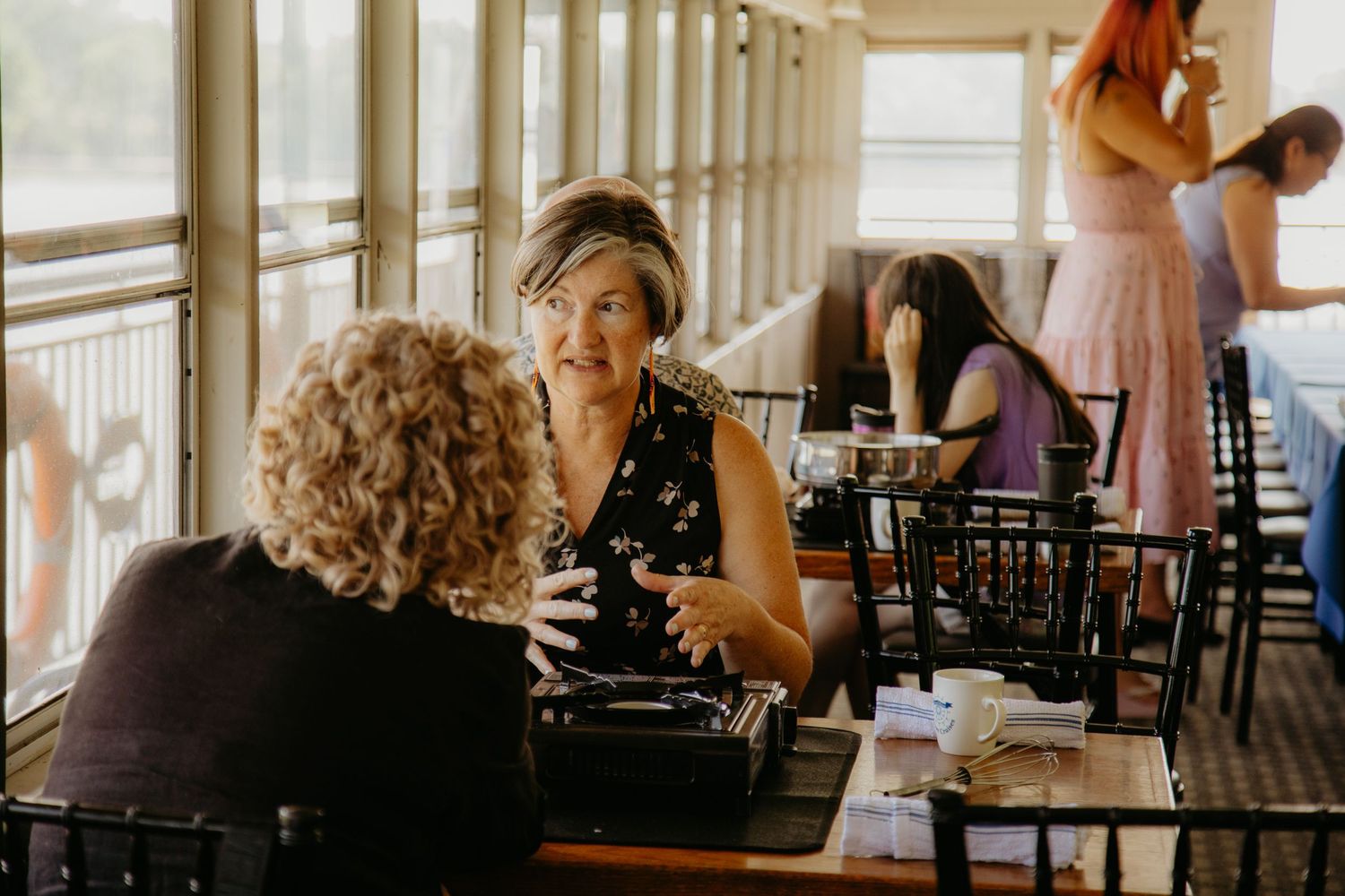 Interior view of a vintage riverboat dining room with wooden tables and chairs.