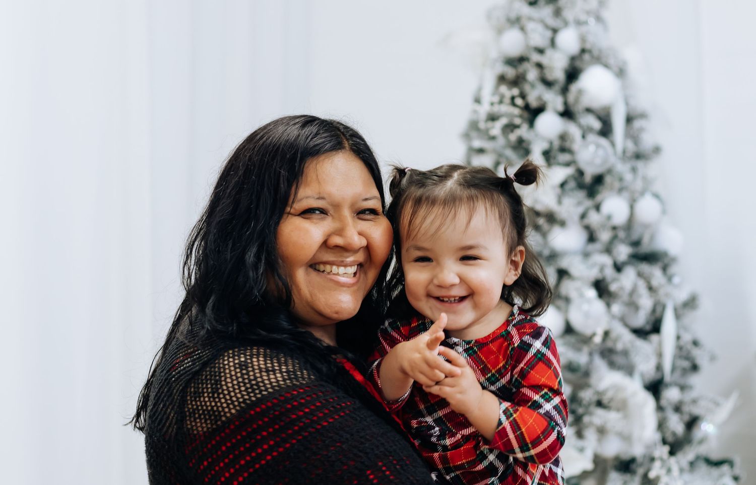 Candid holiday moments captured by decorated white Christmas tree.