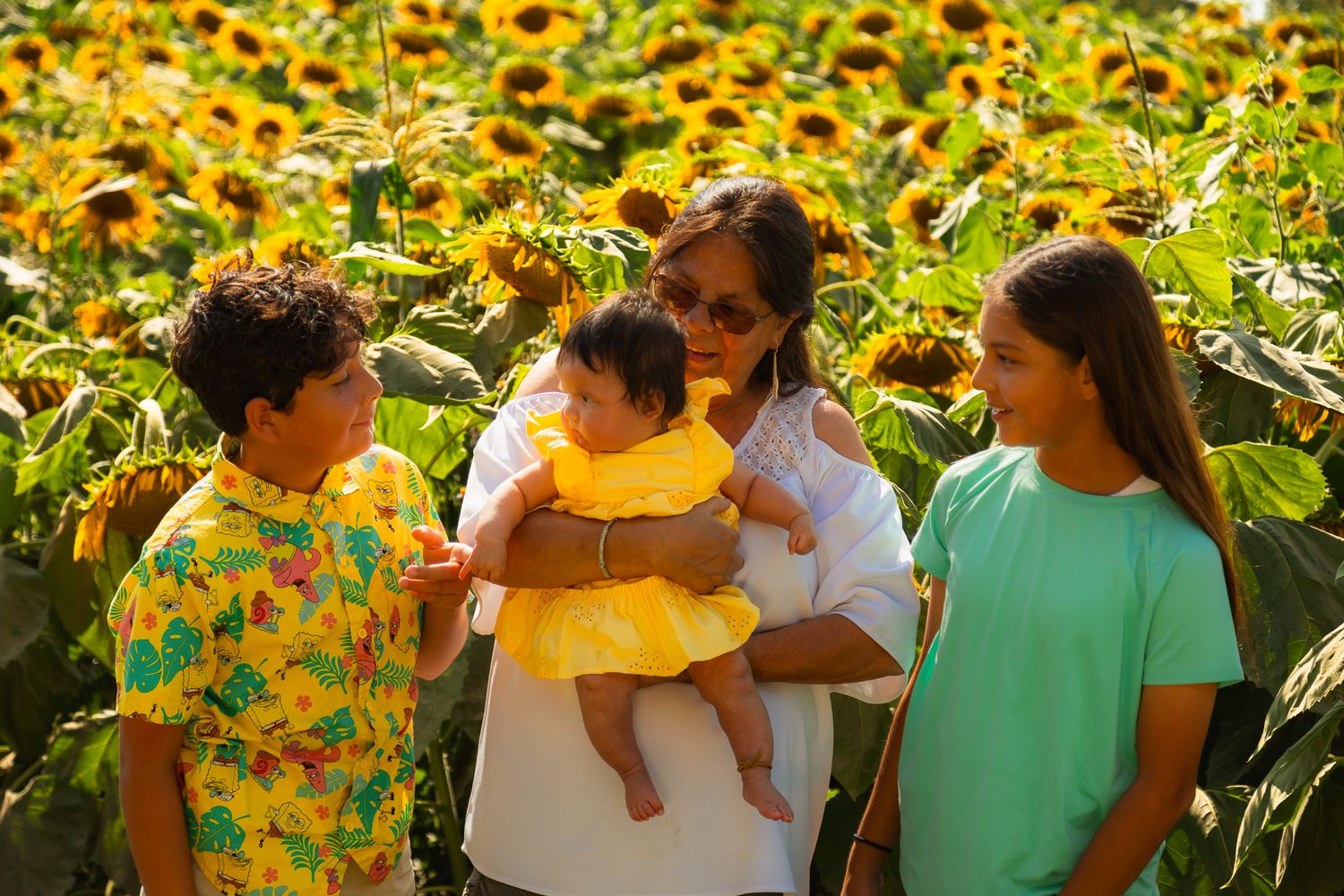 A cheerful family gathering among bright yellow sunflowers on a sunny afternoon.