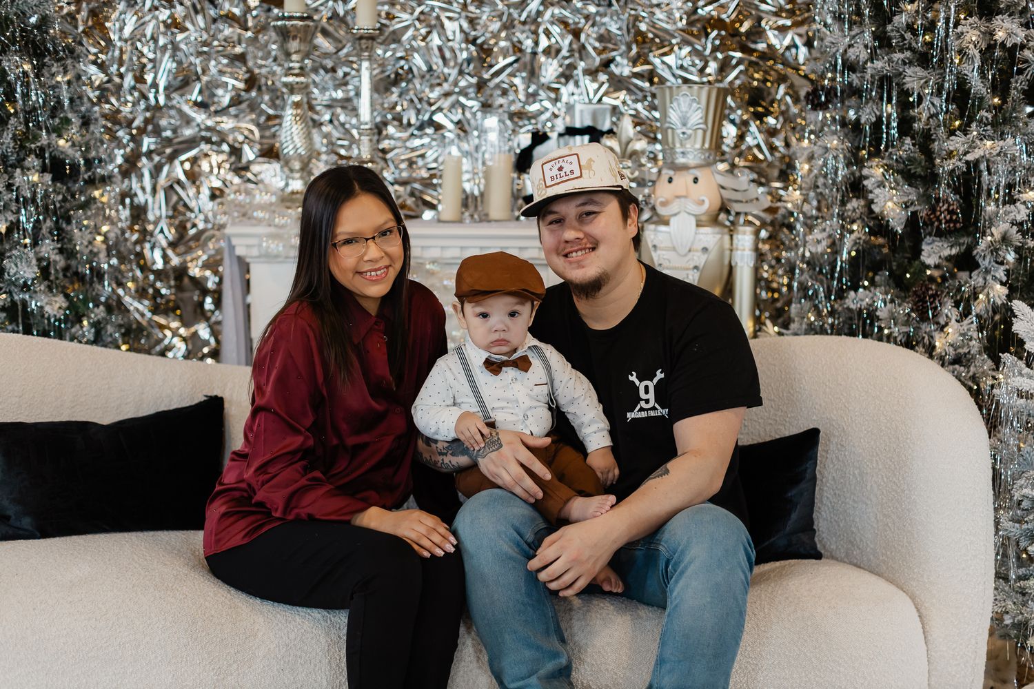Casual family portrait with silver winter backdrop and coordinated outfits.