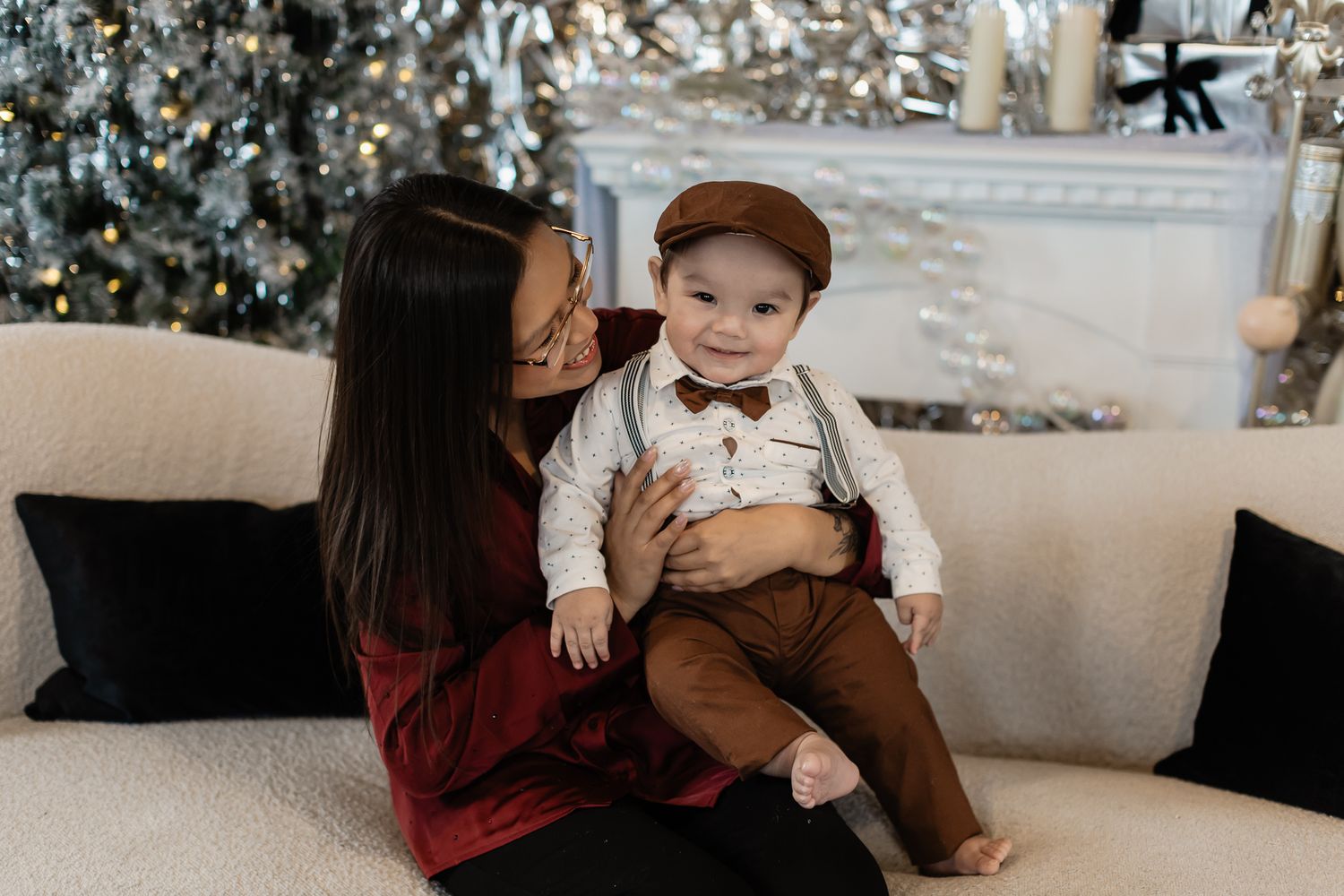 Intimate family moment captured against winter holiday backdrop with sparkly decorations.