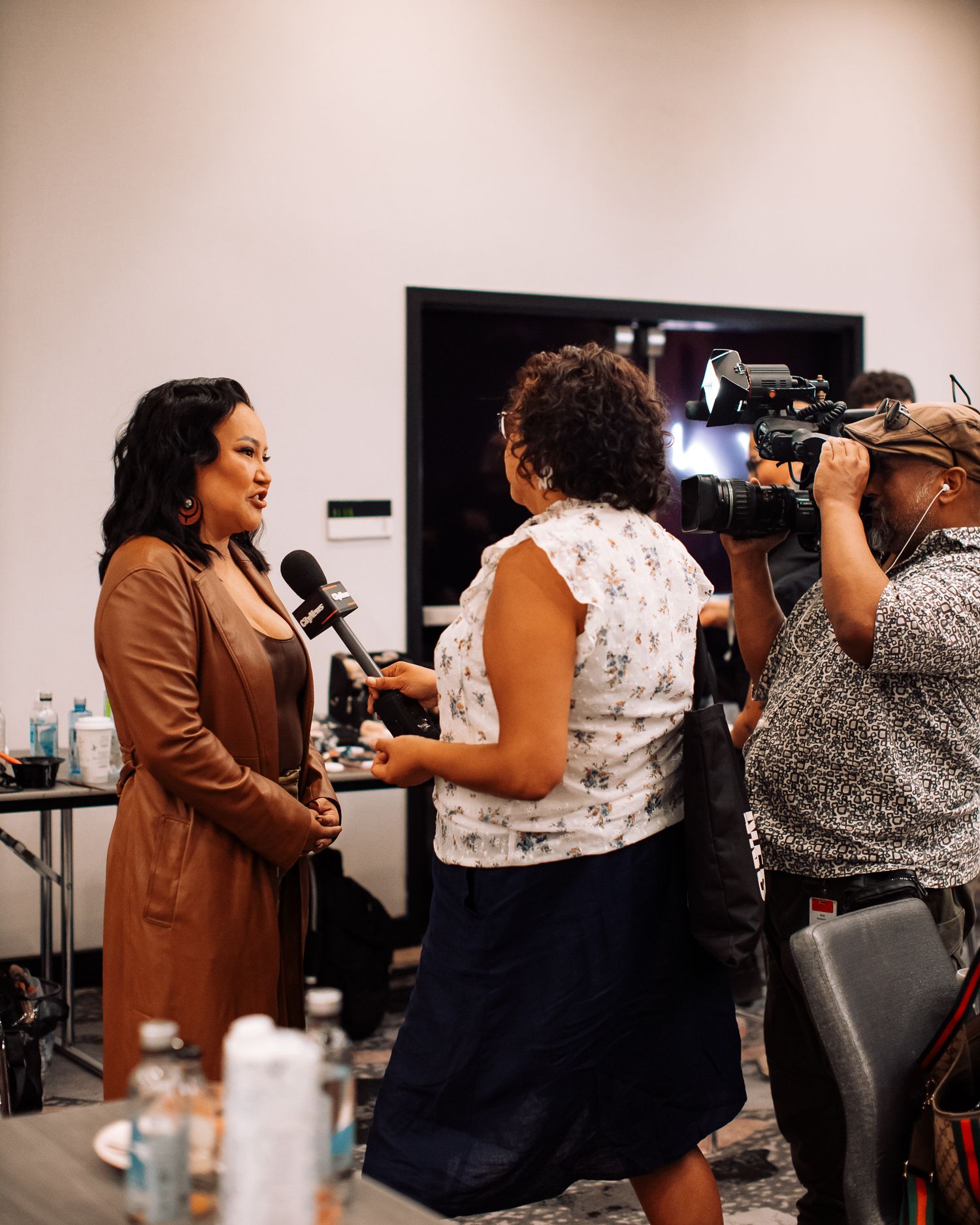 Group of photographers and attendees interacting at an indoor event.