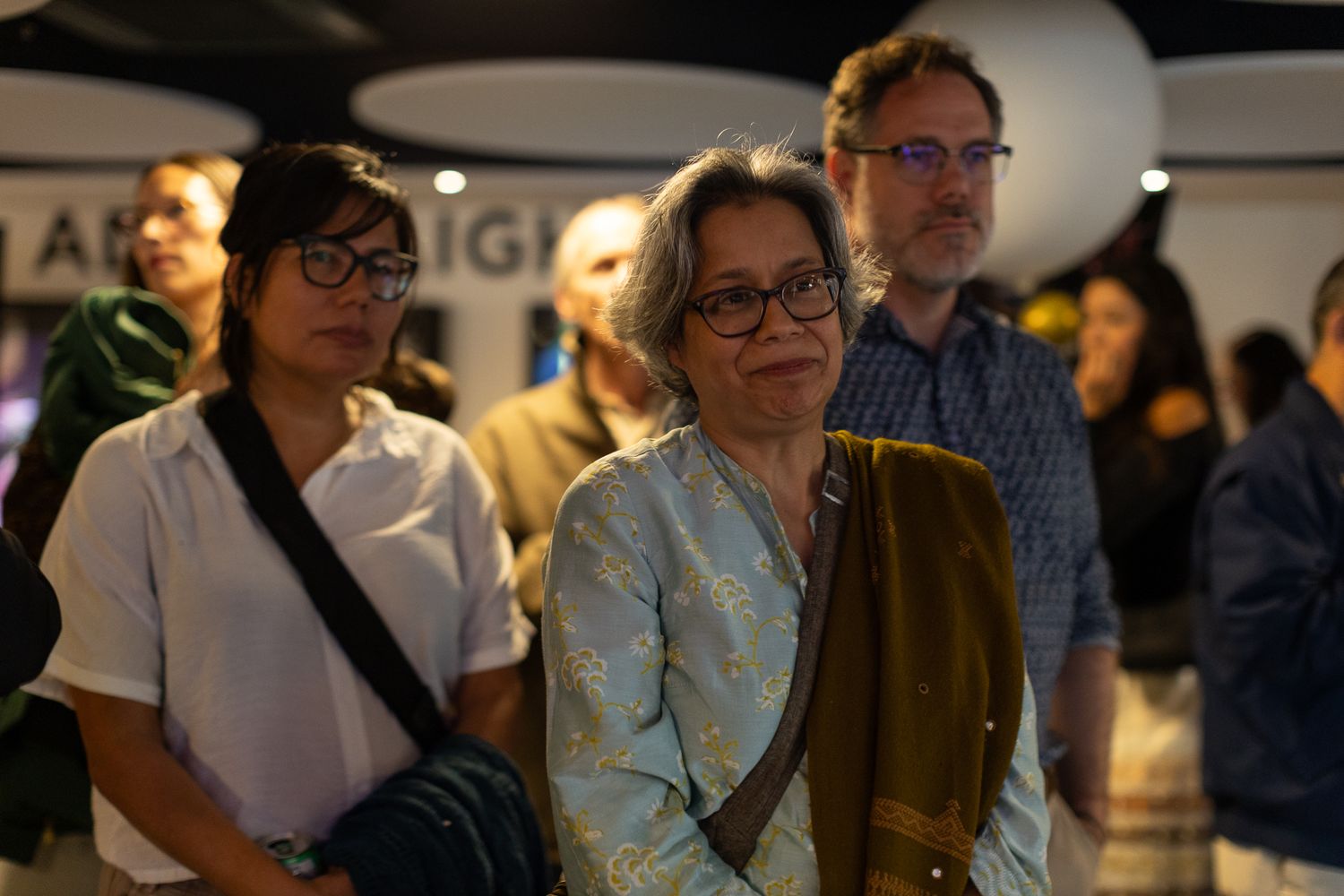 Attendees watching intently during an indoor gathering or presentation.