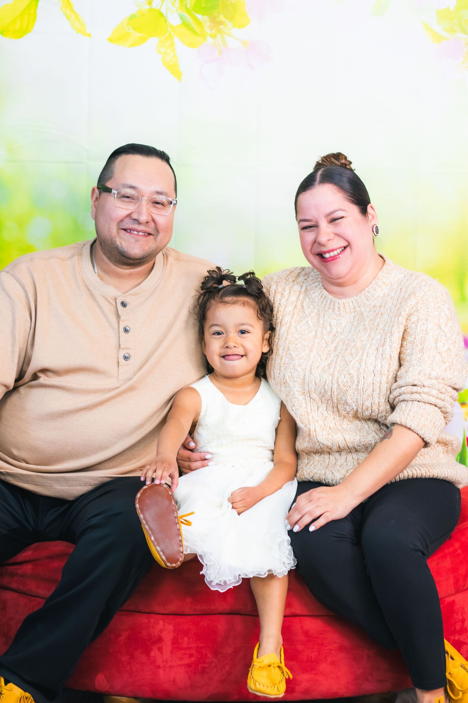 Spring portrait session on red couch with bright yellow background.