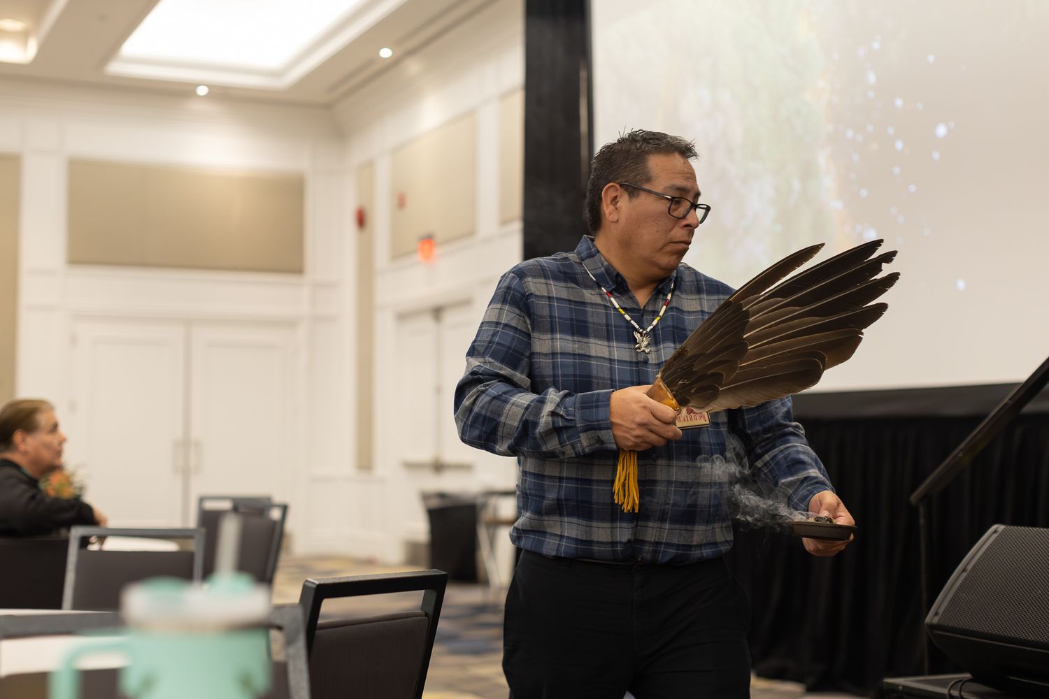 Person presenting at podium during indoor conference or meeting.