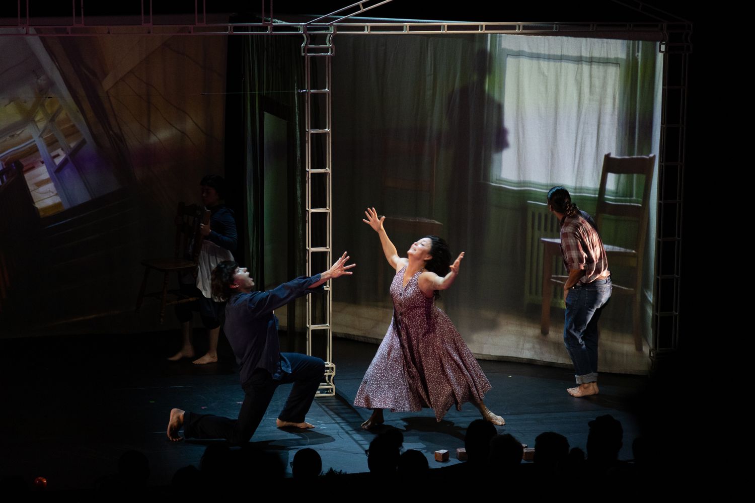 Performers in period costumes dancing energetically on a theatrical stage during a live production.