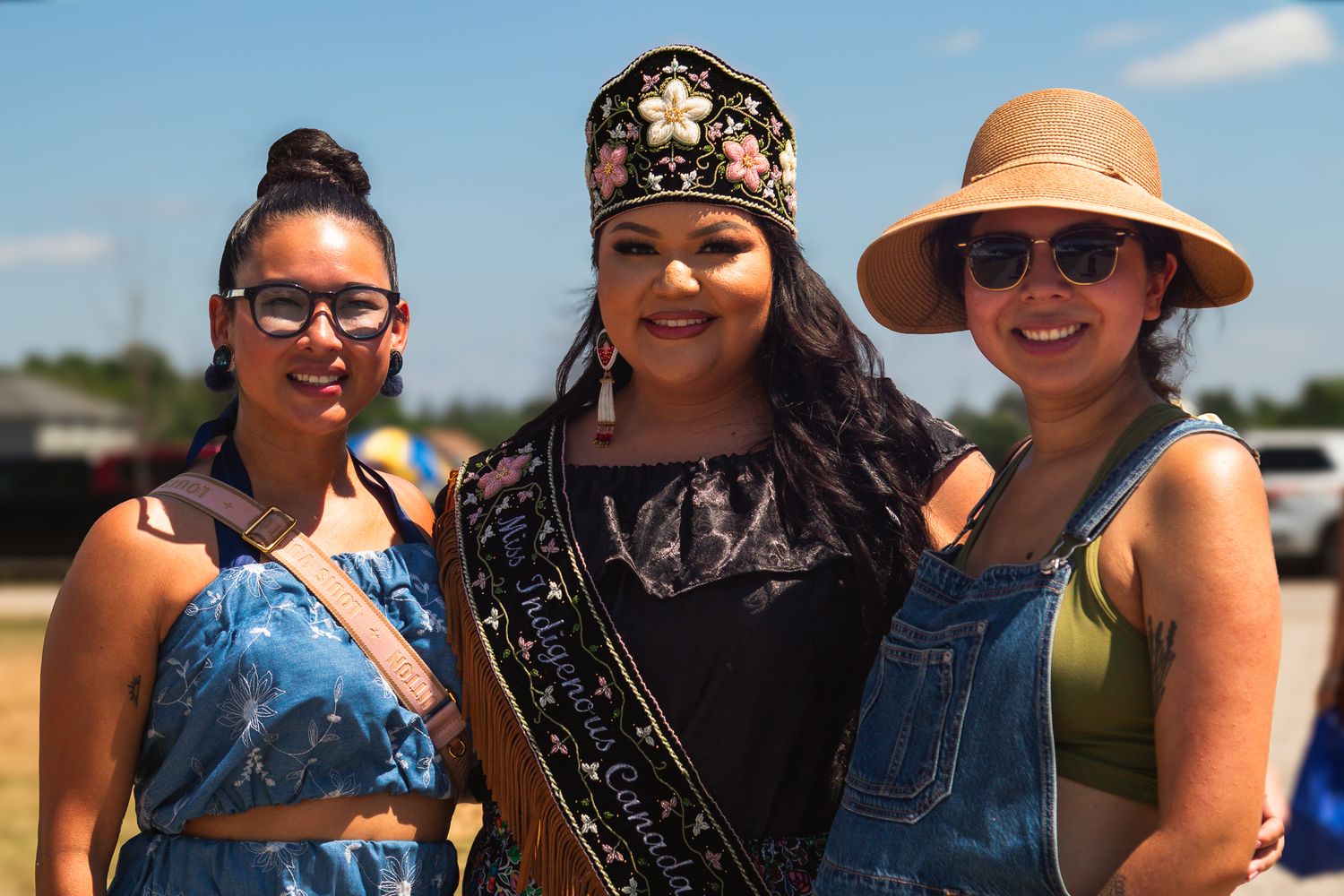 Group of friends enjoying a sunny outdoor celebration with hats and smiles.