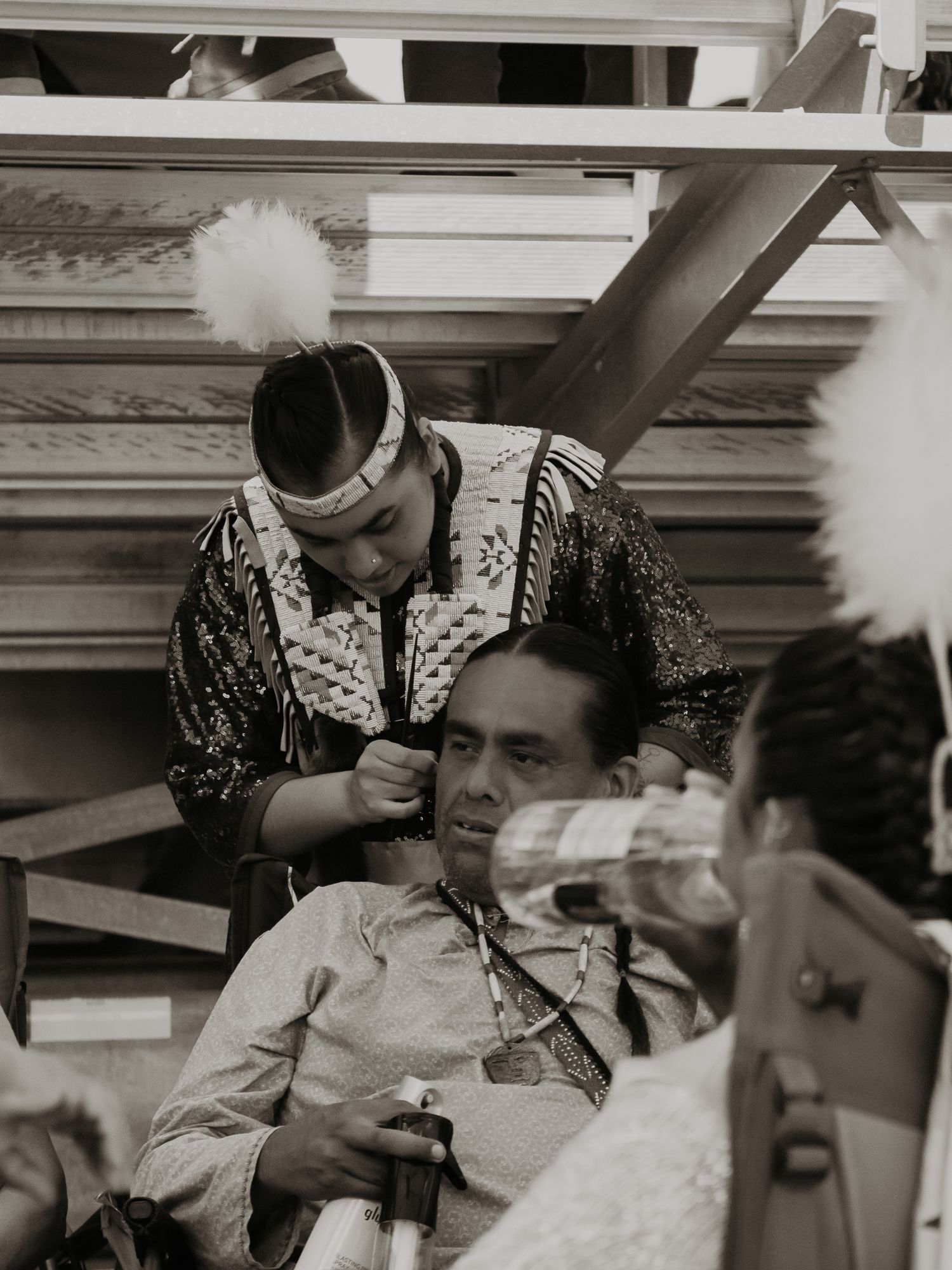 Vintage black and white photograph showing people socializing at a Native American gathering.