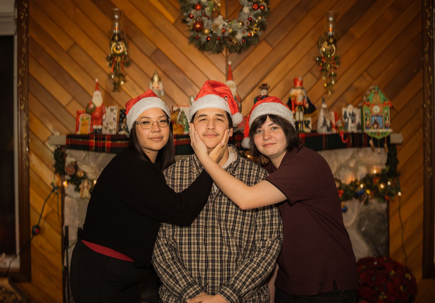 Christmas gathering with decorated tree and wood paneled walls in warm lighting.