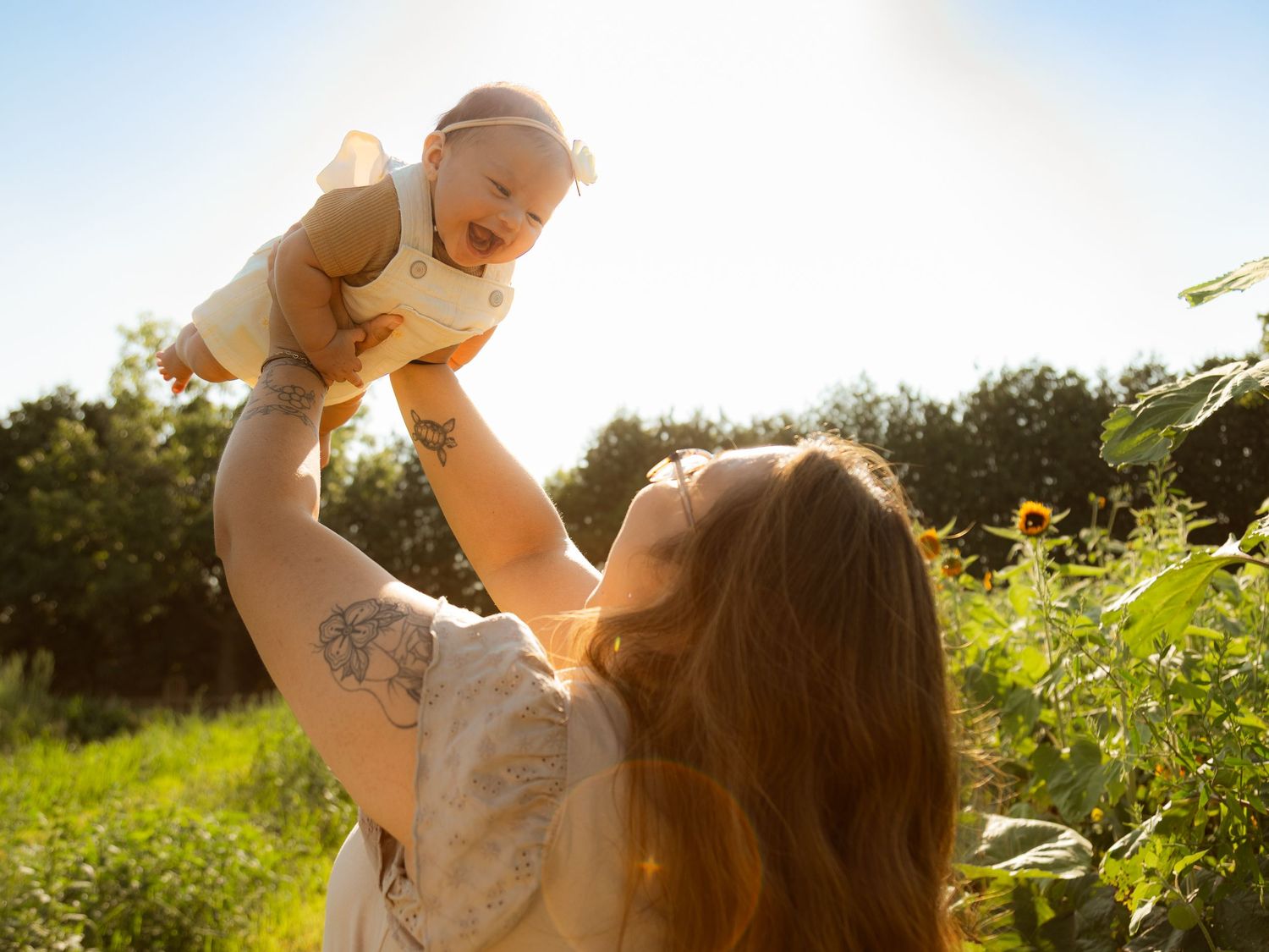A joyful moment captured against a bright summer sky in a sunlit field.