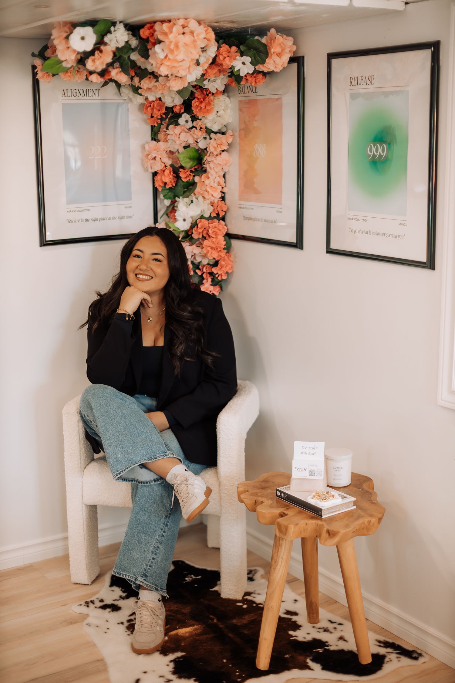 Modern nail salon interior with pink floral decor and framed certificates on white walls.