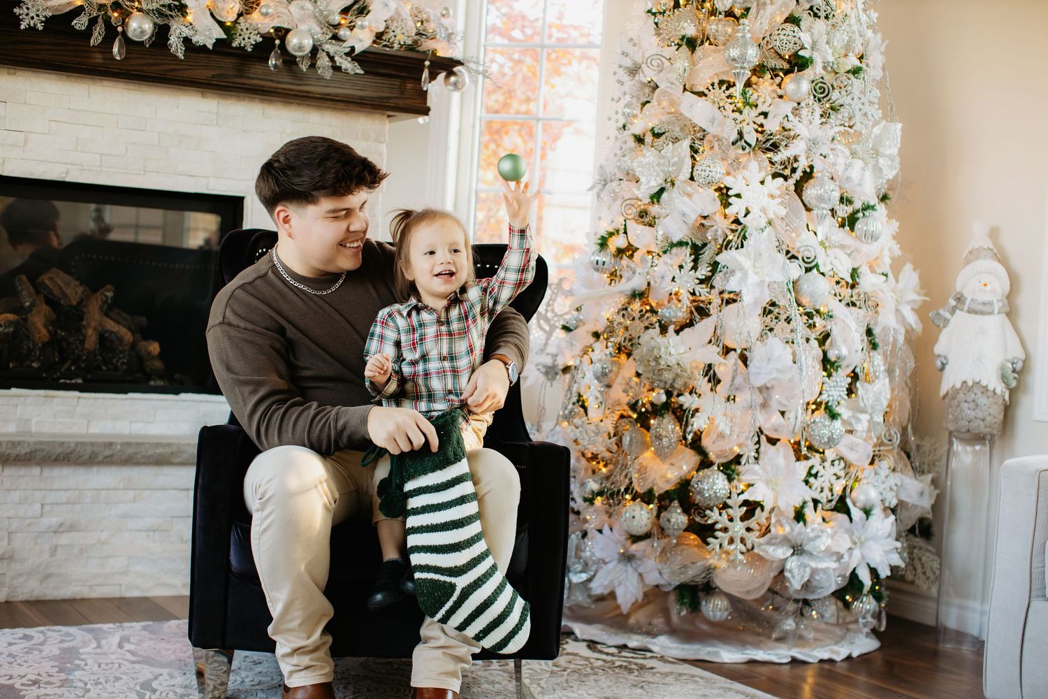 Holiday living room decorated with elegant white Christmas trees and cozy seating.