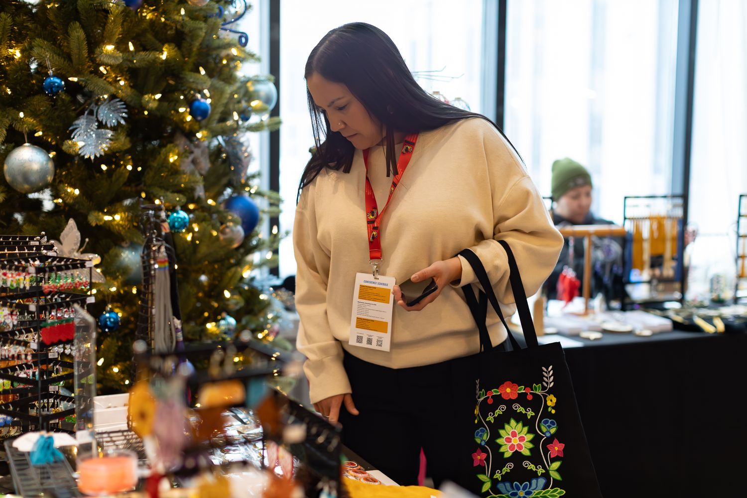 Decorated Christmas trees and event displays visible through large windows.
