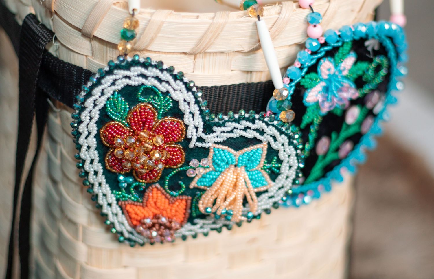 Close-up of intricate beadwork on basket featuring turquoise and red floral designs.