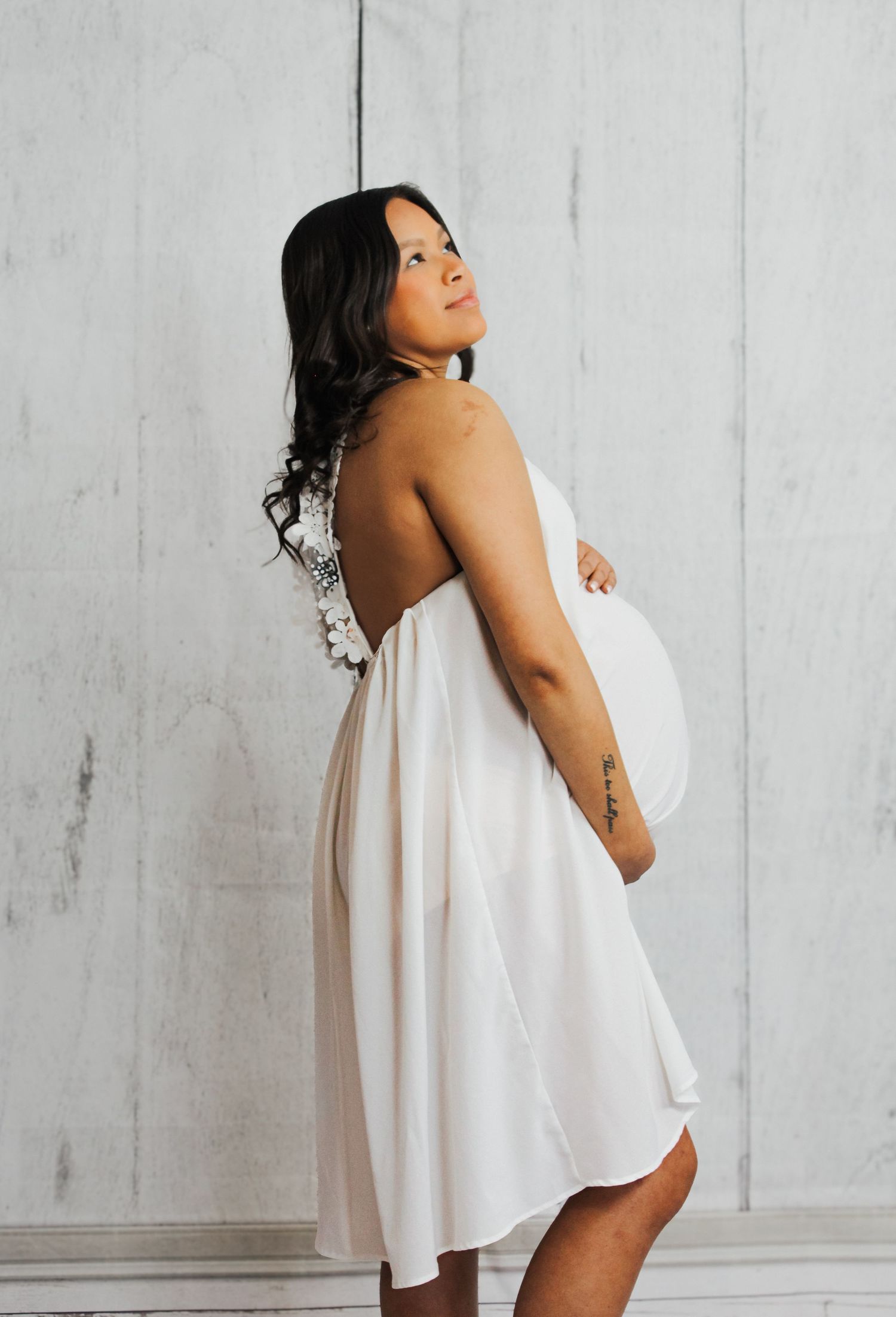 Creative maternity photos showing silhouette with flowing white fabric.