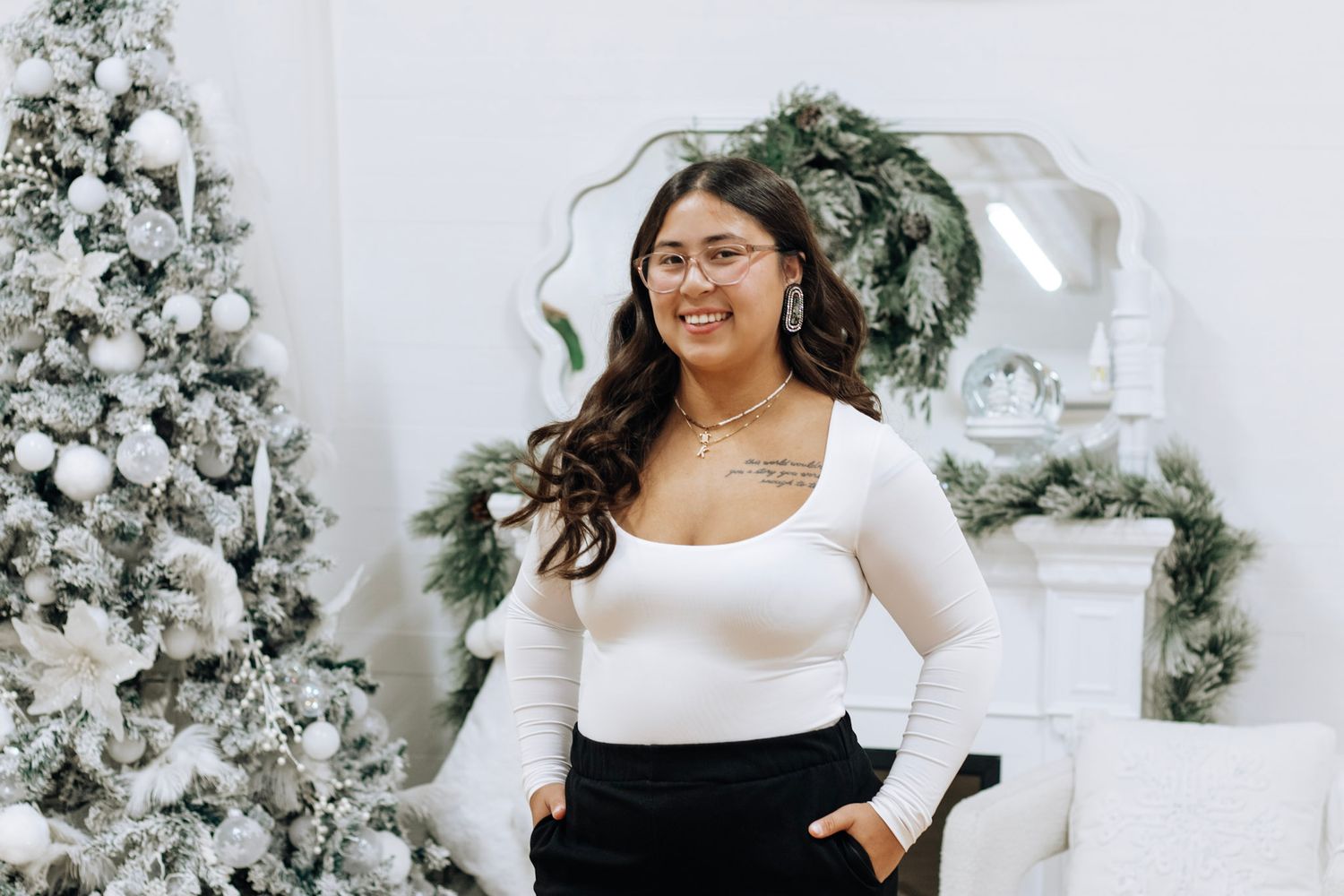 White and black outfit styling against a winter wonderland backdrop with flocked trees.