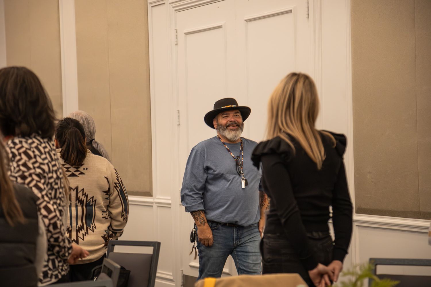 People mingling in a beige-walled conference or event space.