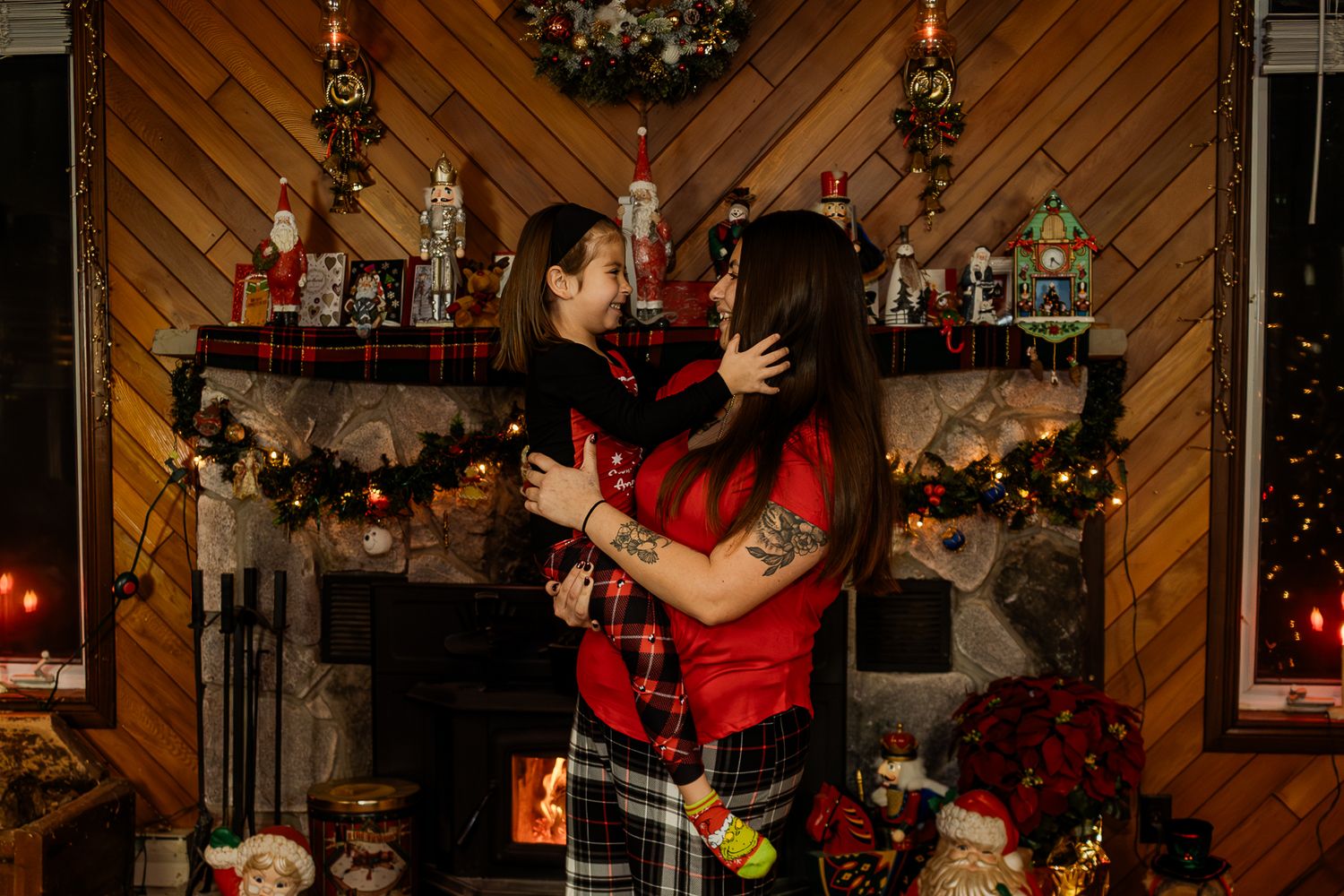 Christmas family photo with decorated tree and diagonal wood wall paneling in background.
