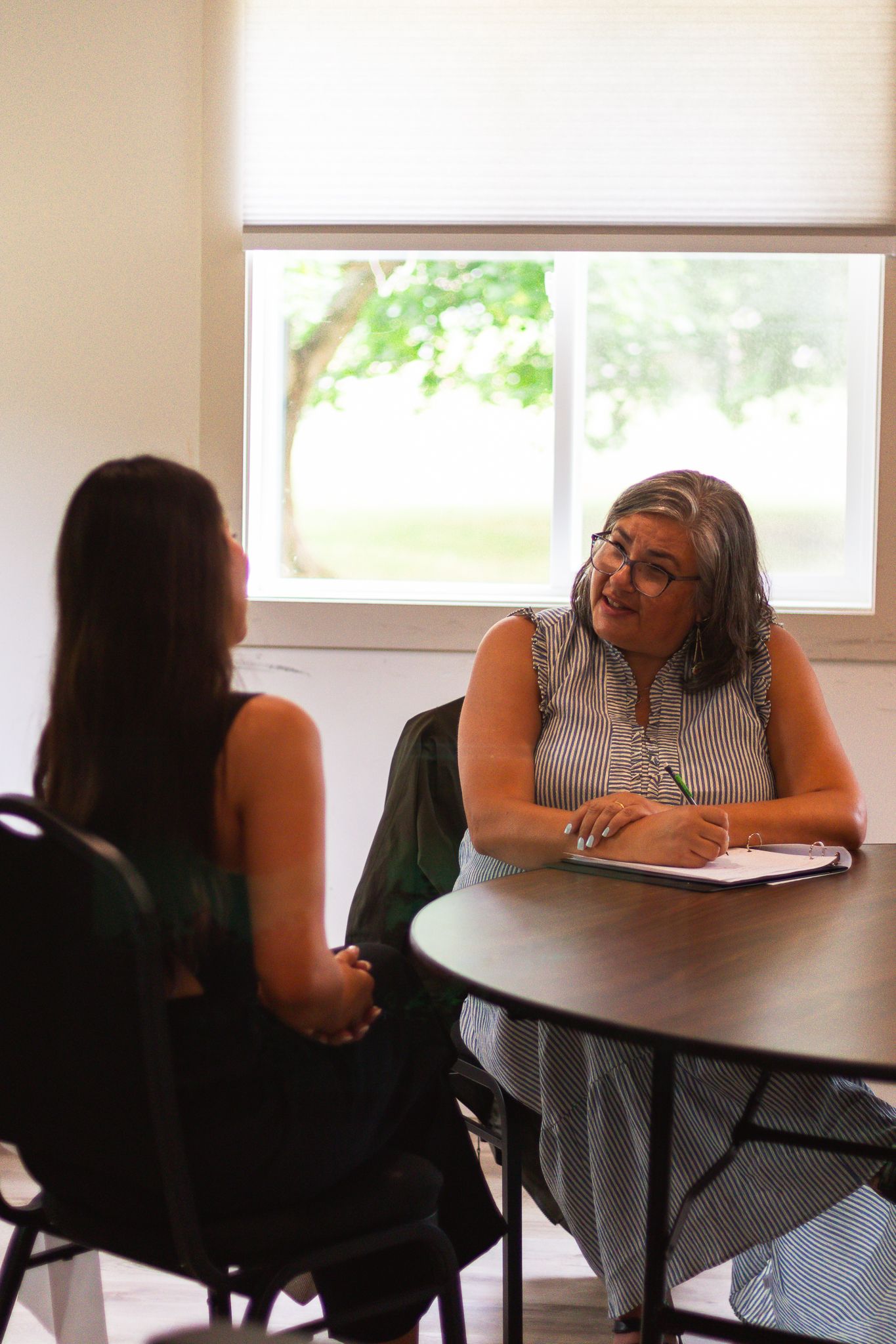 Meeting scene at table with participants engaged in discussion.