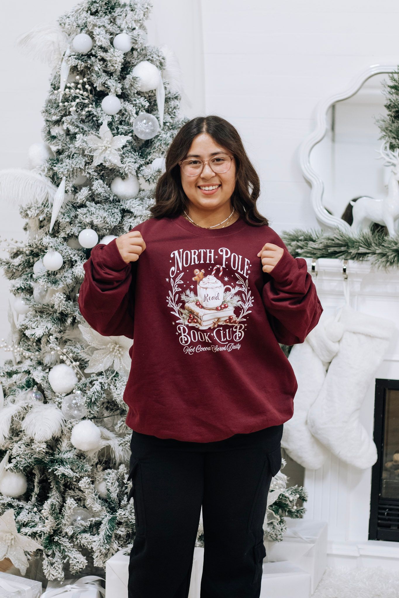 Burgundy North Pole themed sweatshirt displayed in a winter wonderland setting.