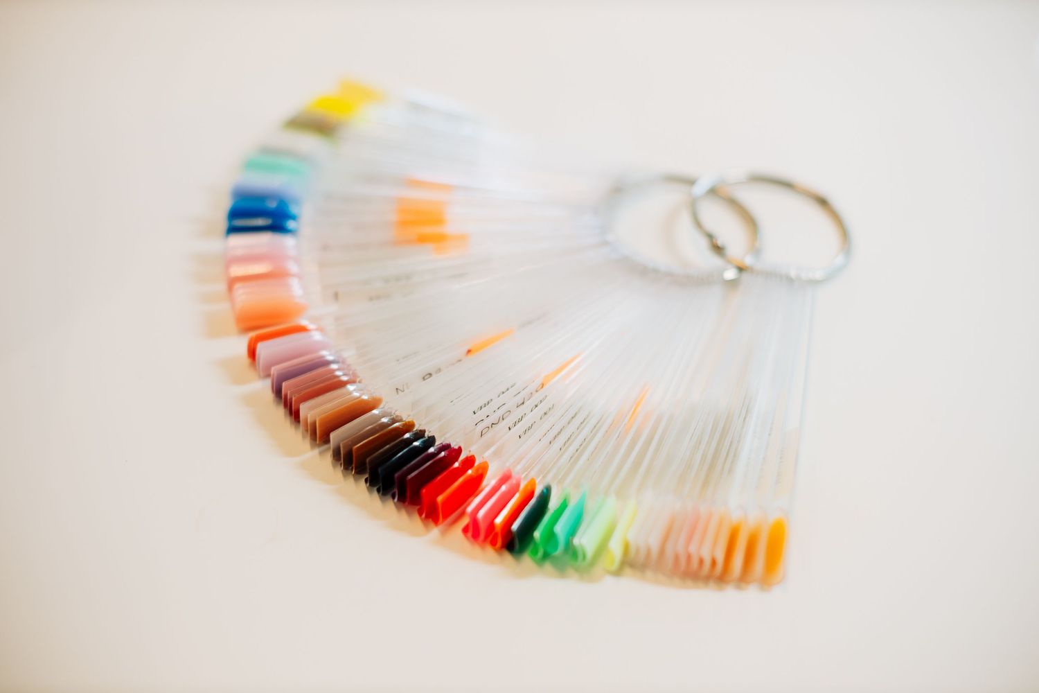 Colorful nail polish sample swatches displayed in a fan pattern.