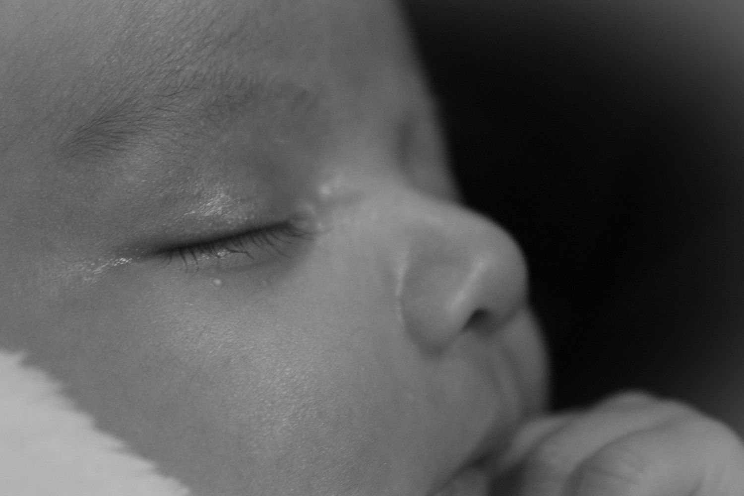 Artistic black and white close-up of sleeping infant's facial features.