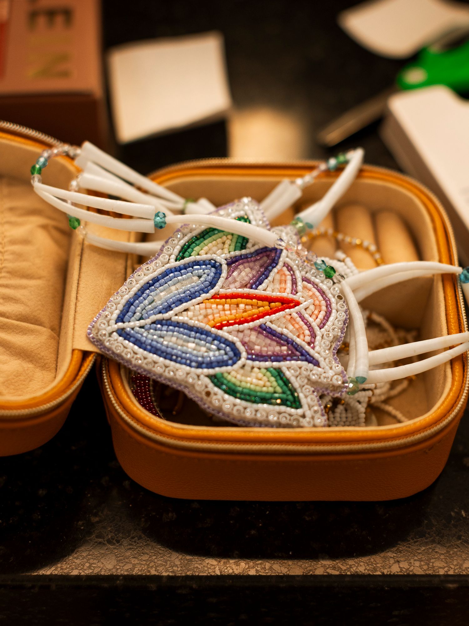 Colorful beaded Indigenous crown with floral design displayed in jewelry box.