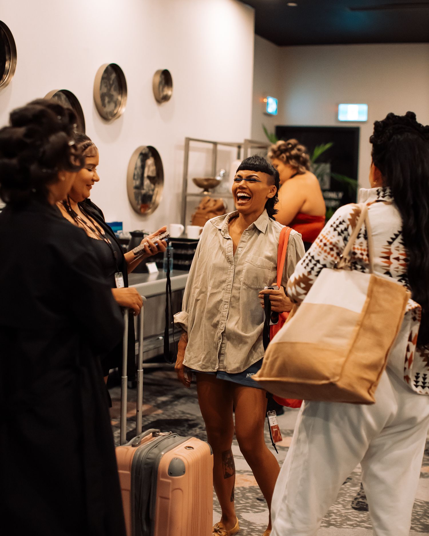 People gathering with shopping bags and luggage in an indoor space.