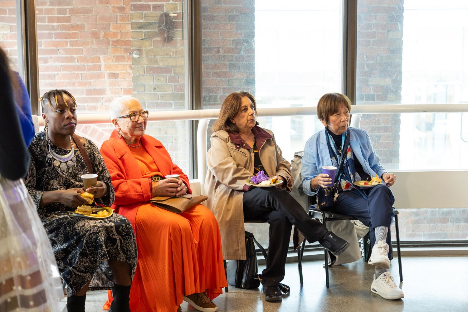Group of audience members seated in casual attire during an indoor event.