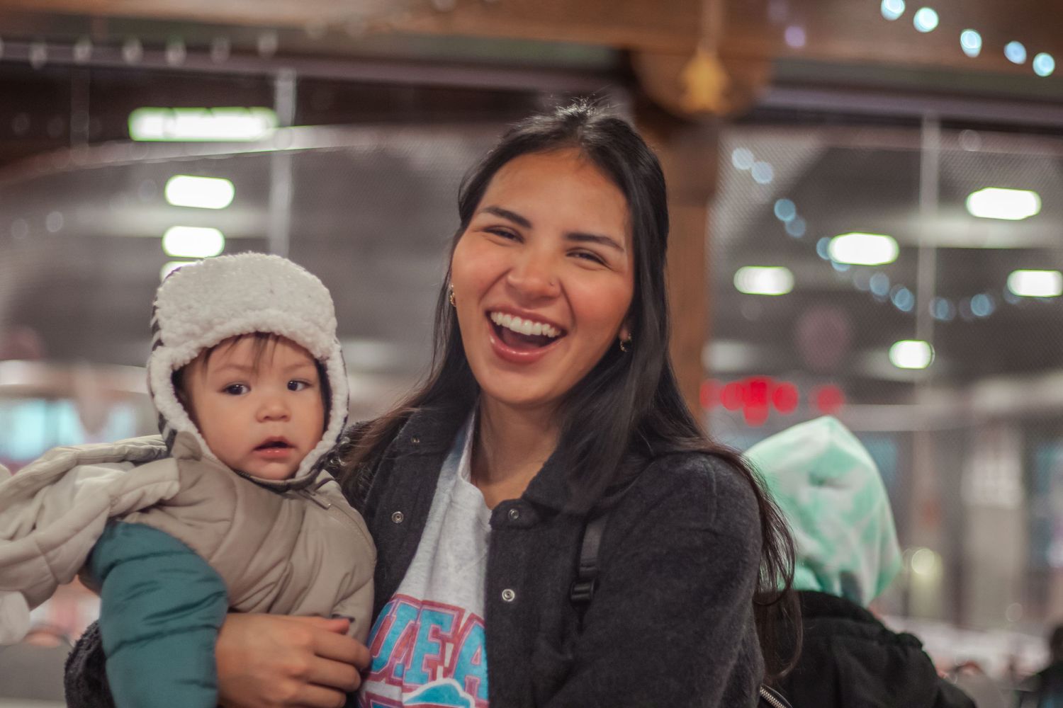 Candid nighttime portrait with warm lighting and casual winter attire.