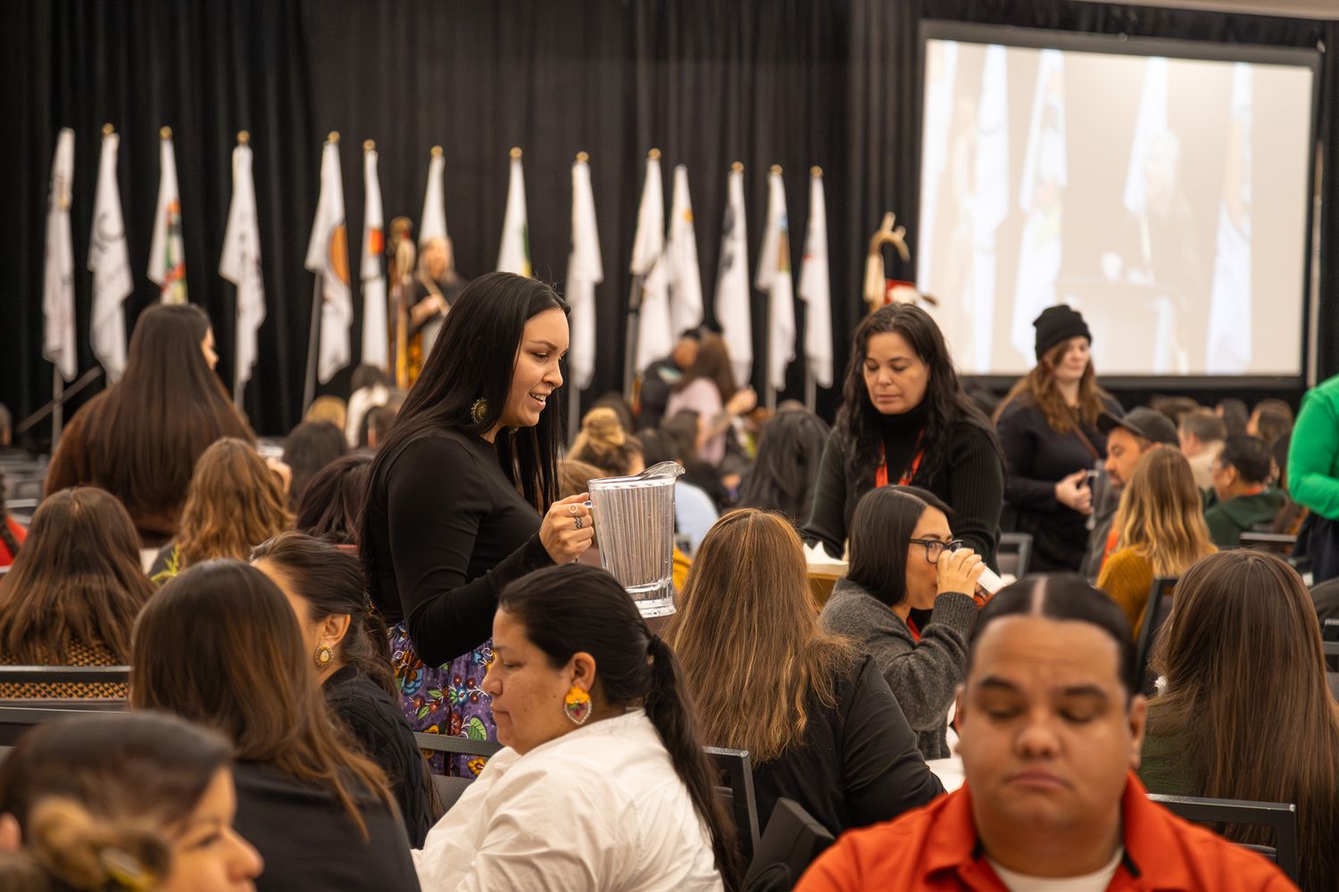 Crowded conference hall with attendees seated in rows during a presentation or meeting.