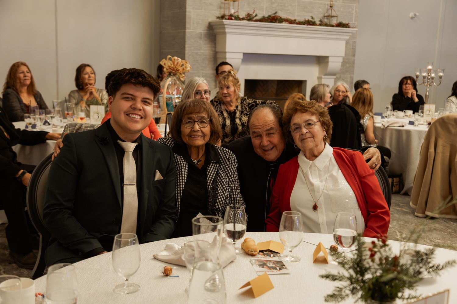 Group enjoying a formal dinner gathering at an elegant white-themed venue.