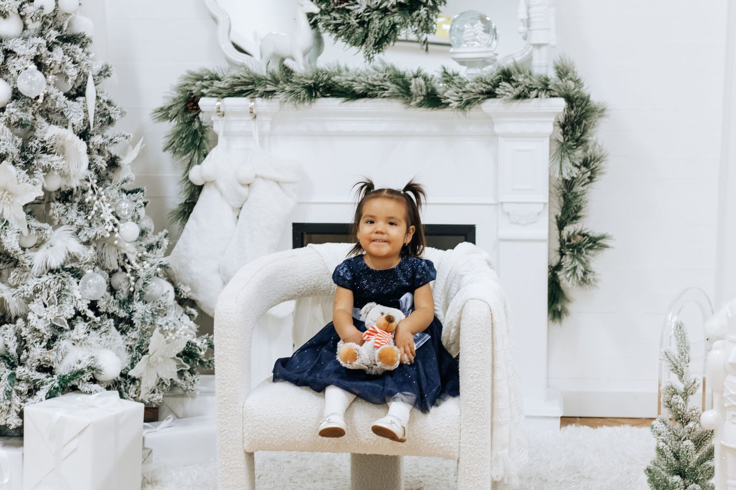 Candid moments captured during a winter-themed studio photoshoot with white Christmas decorations.