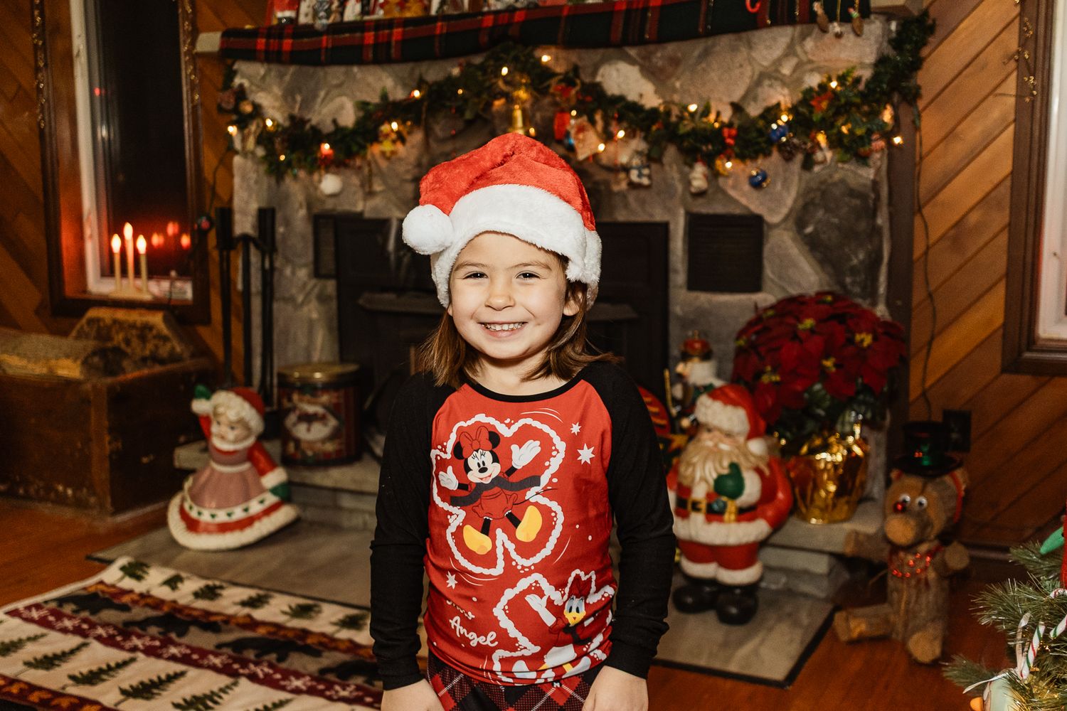 Holiday portrait with Christmas tree and decorative red stockings hanging in background.