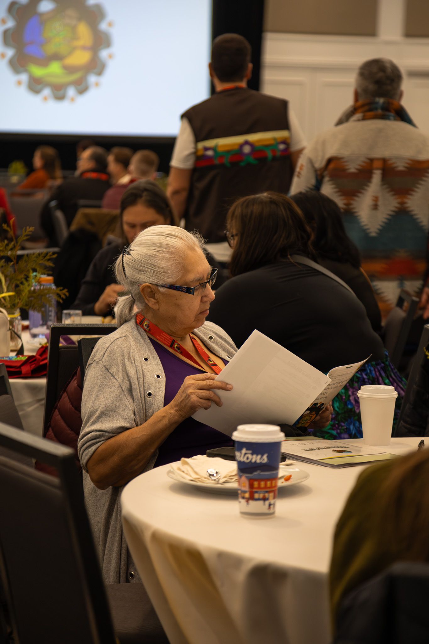 Attendees seated at round tables during a conference or banquet event.