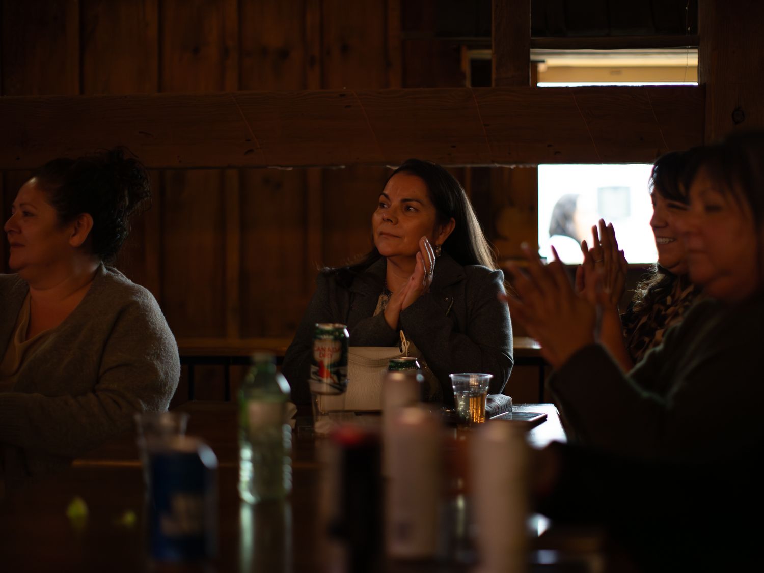 People gathered at tables in a dimly lit restaurant or bar setting for a social event.
