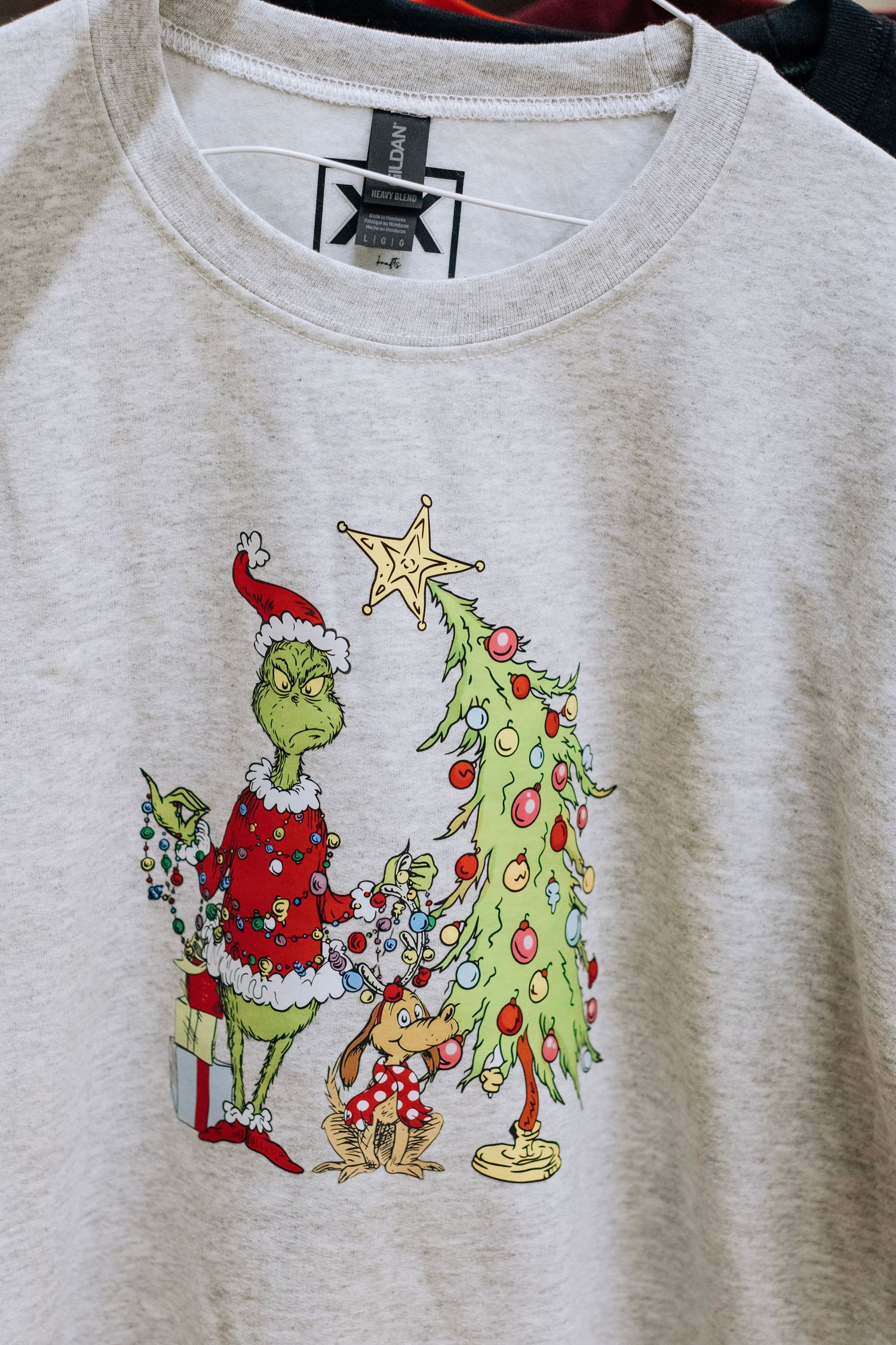 Gray sweatshirt with Grinch-themed Christmas illustration print design.