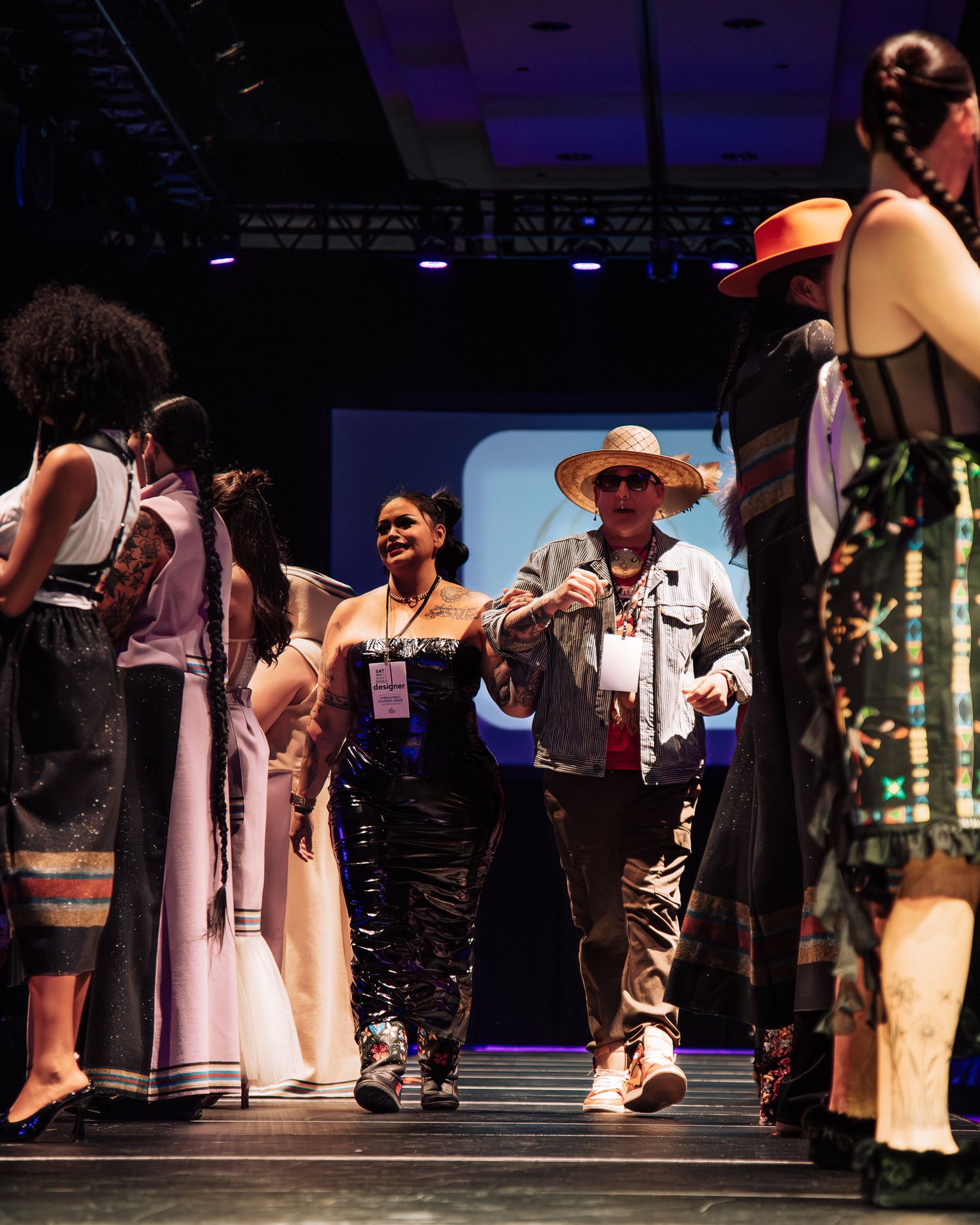 Fashion show models walking runway in traditional and contemporary designs.