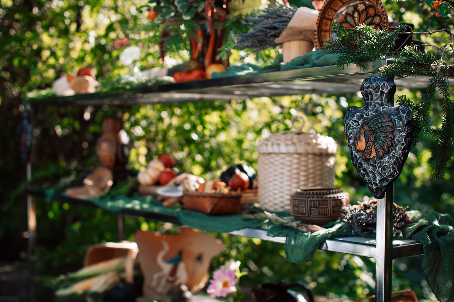 Rustic outdoor shelves adorned with wicker baskets, terracotta pots, and natural decor surrounded by lush green foliage.