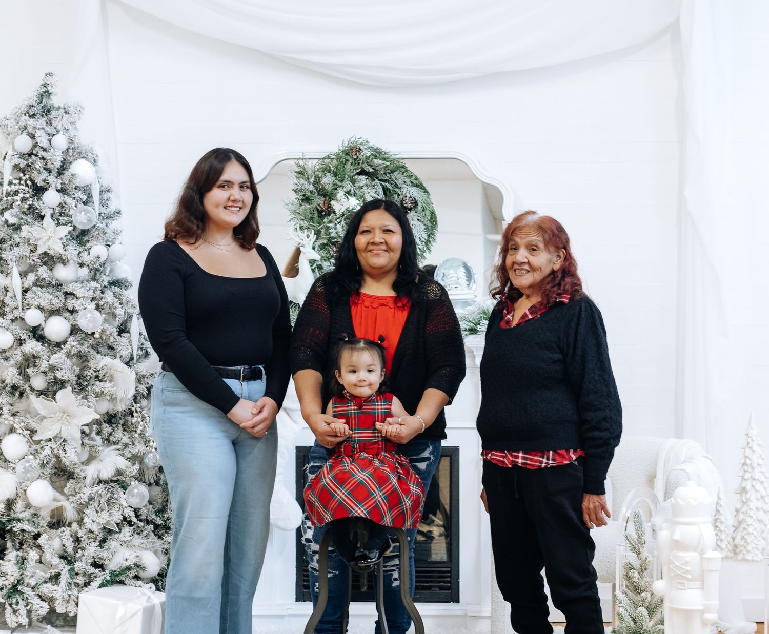 Festive family gathering by decorated Christmas tree with white and silver ornaments.