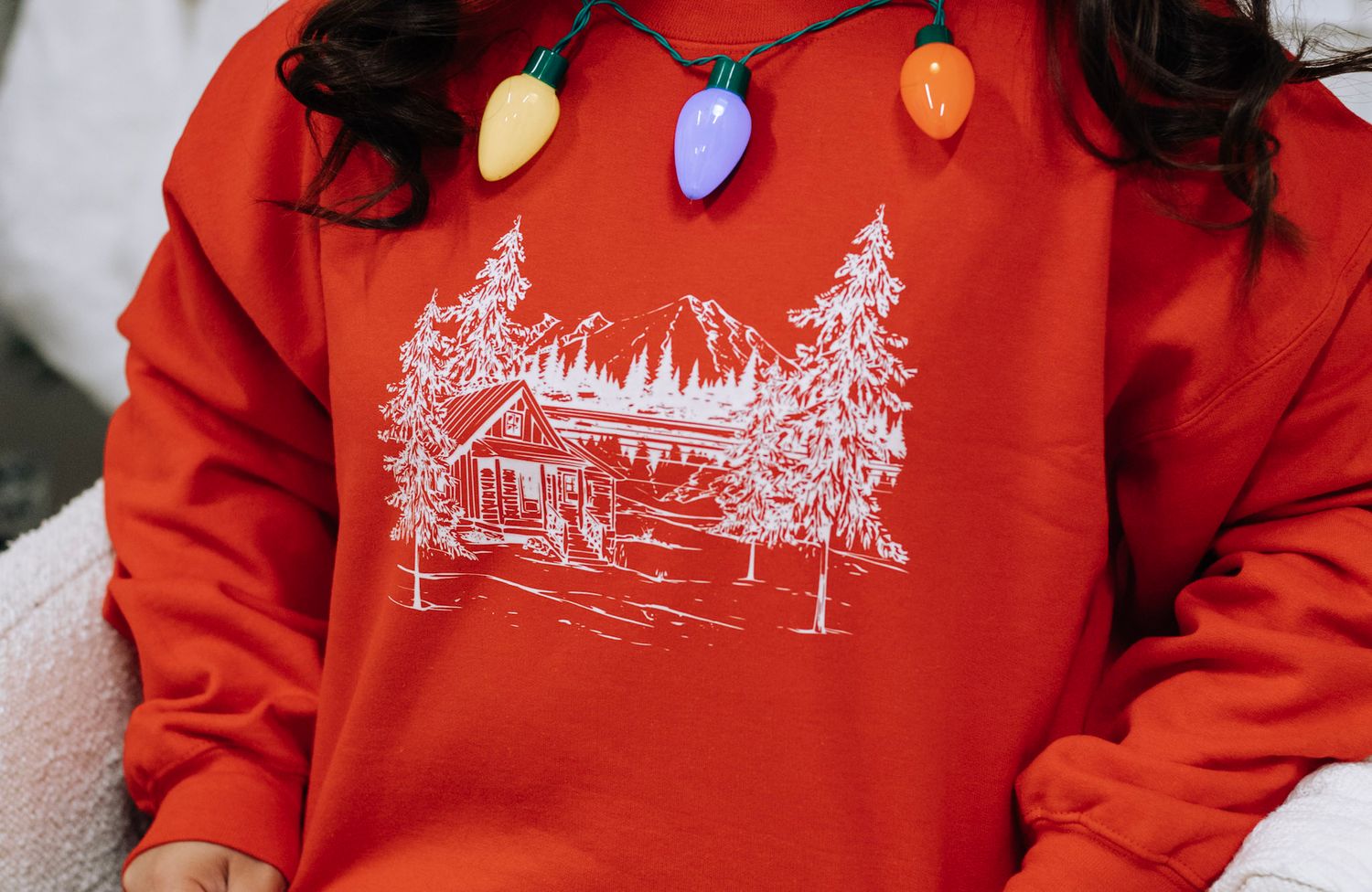 Red holiday sweatshirt collection featuring winter scenes and festive designs.
