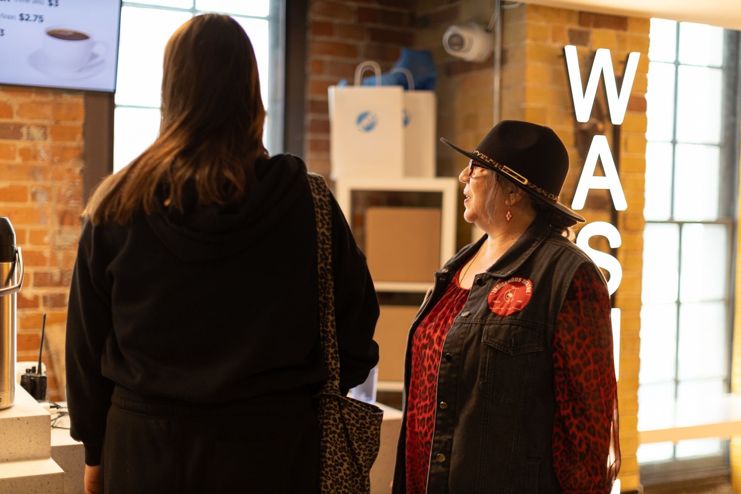 Interior scene of retail space with exposed brick wall and signage.