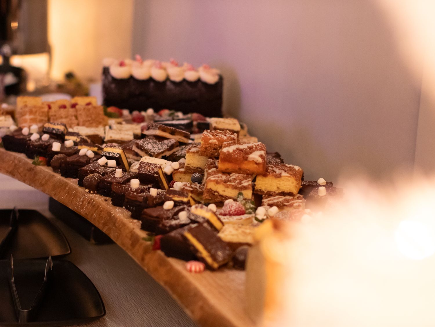 Display of desserts and treats arranged on a curved serving table.