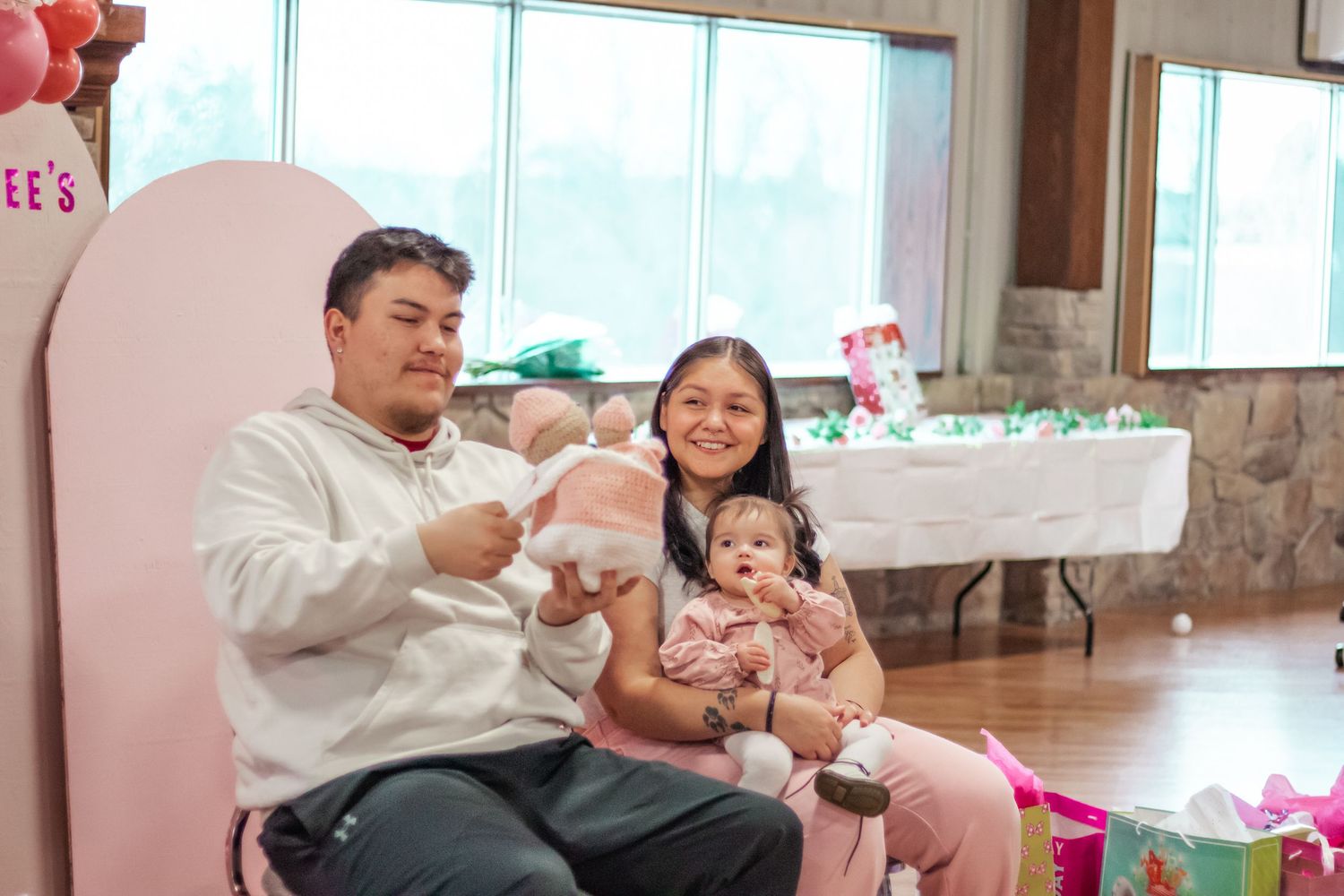 Pink-themed party setup with balloons and decorative elements in a bright room.